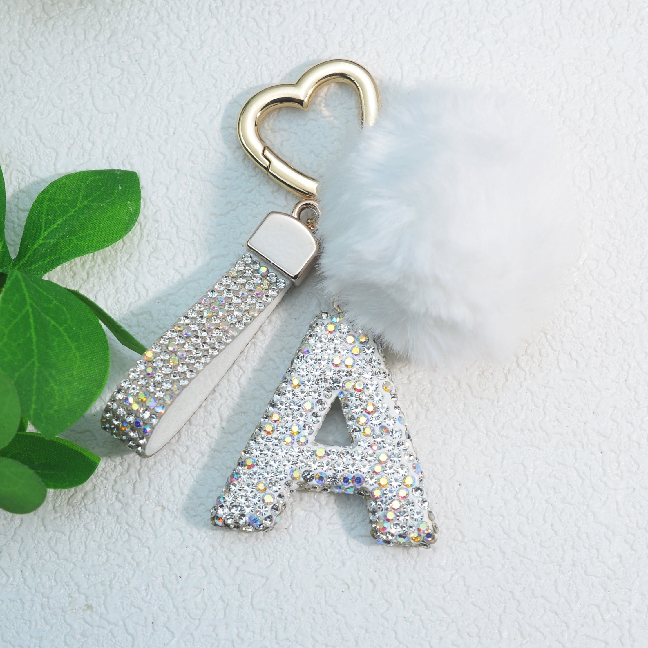 Llavero de PVC con iniciales de pedrería rosa y blanca con cierre de puño para mujeres