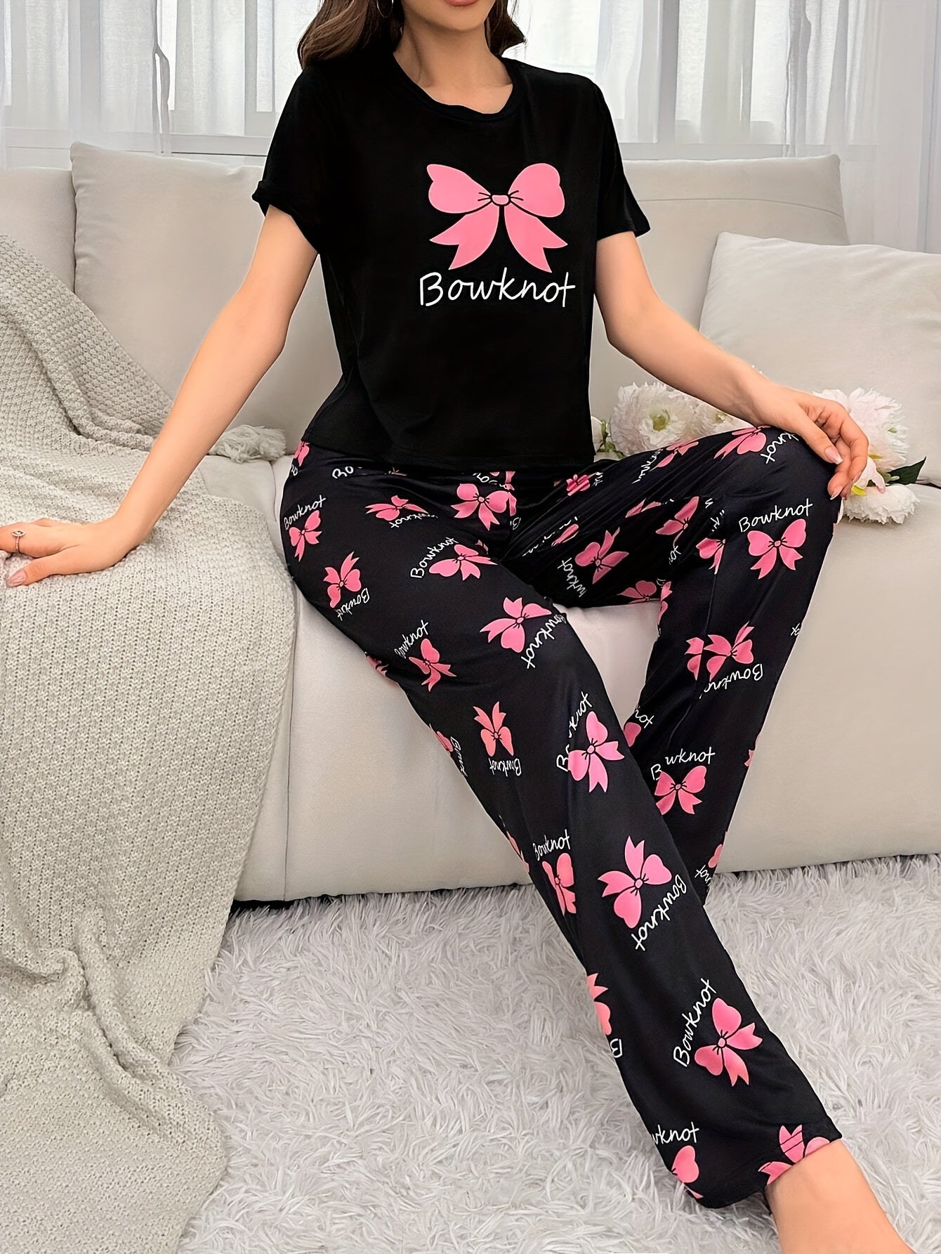 Ayollar uchun qisqa yengli va elastik belli shimlar bilan qulay bog‘ichli pijama to‘plami. Qora rangda, pushti kapalak printi bilan yumshoq, mashinada yuviladigan polyester aralashmasidan tayyorlangan.