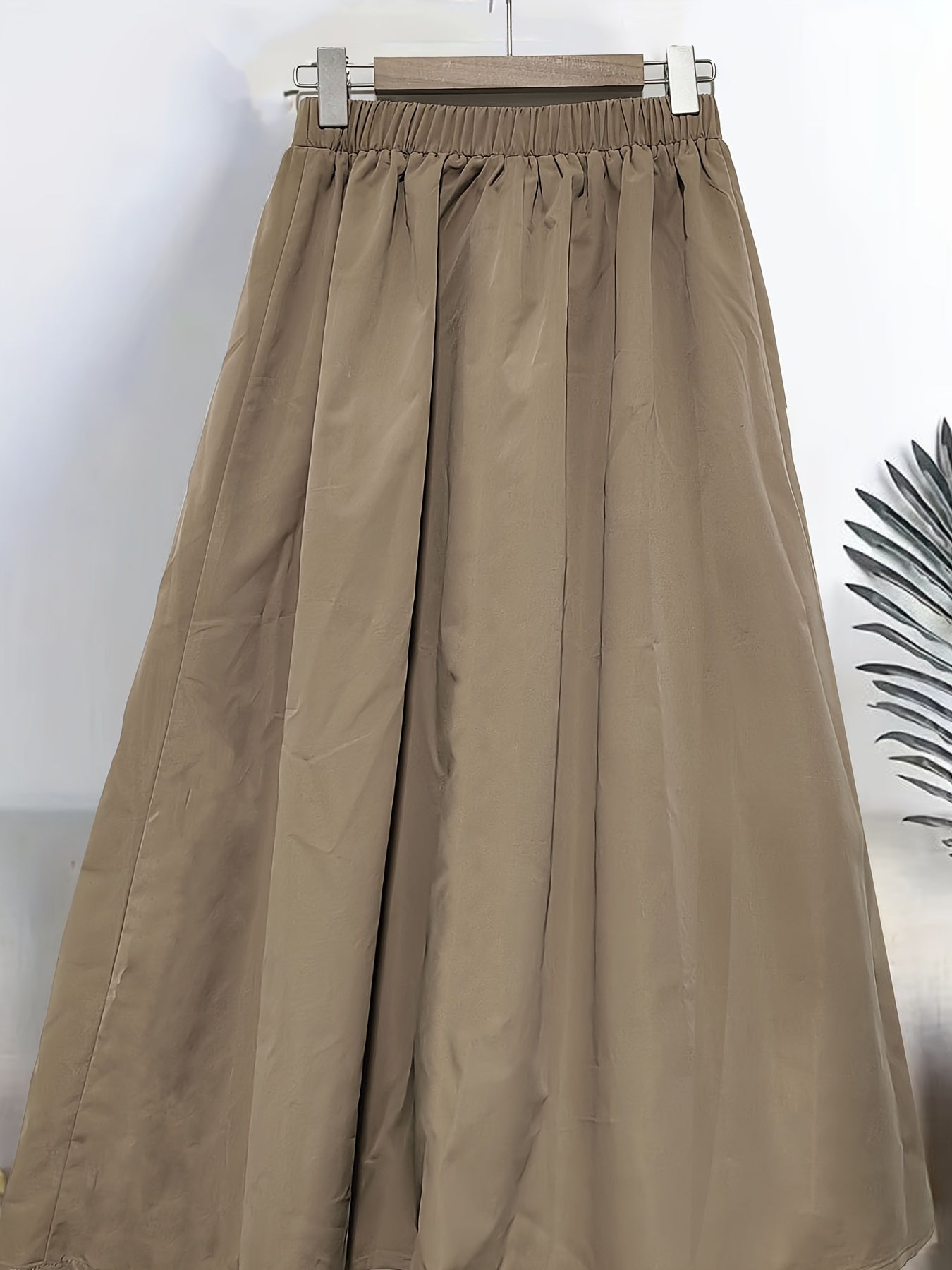 Yoz va bahor uchun katta o'lchamdagi ayollar uchun elastik belga ega bir rangli A-siluetli yubka.