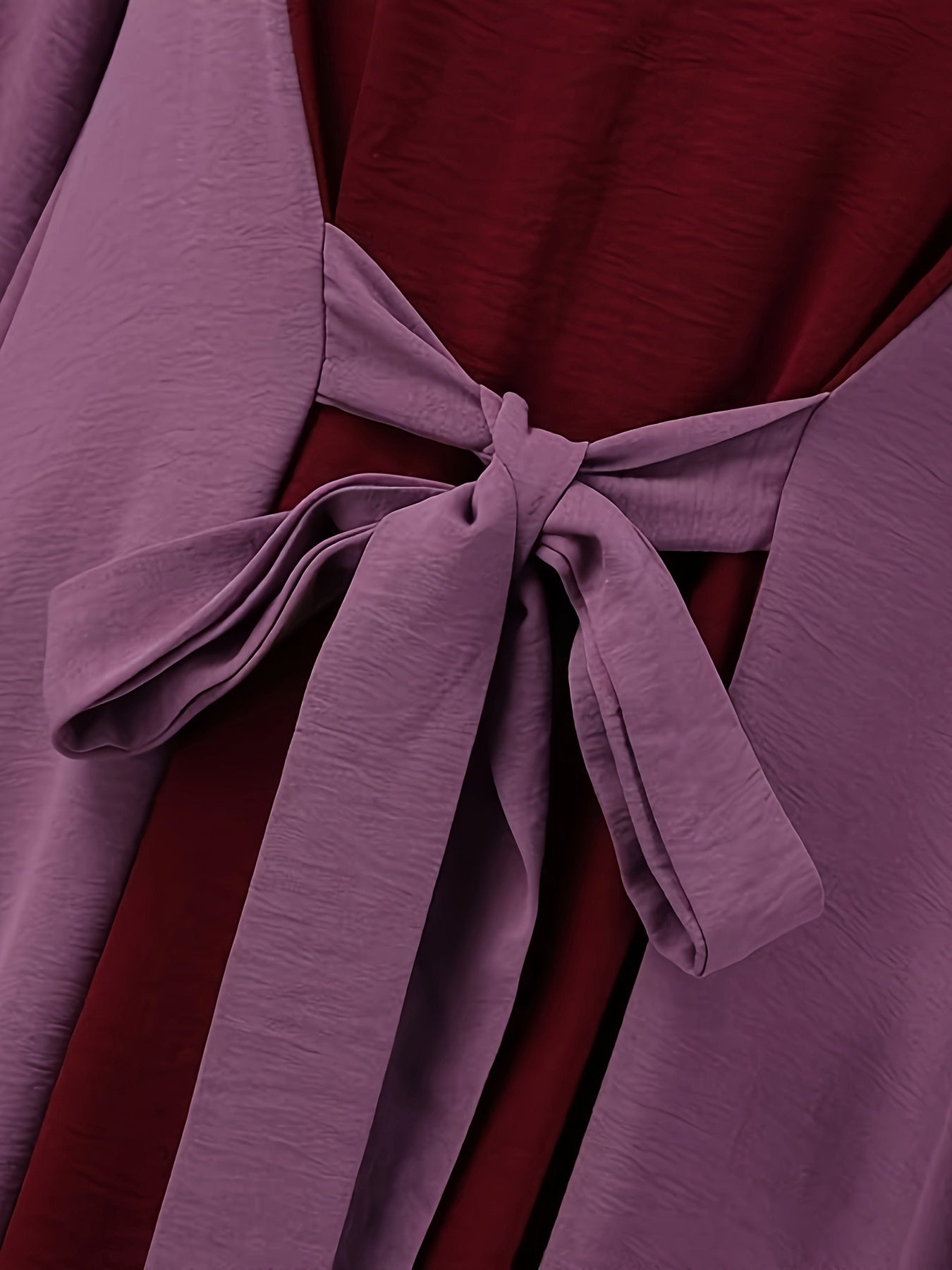 Ramazon ilhomlangan uzun ko'ylak, rangli kontrastli bel bog'ichi bilan, tashriflar uchun mukammal.