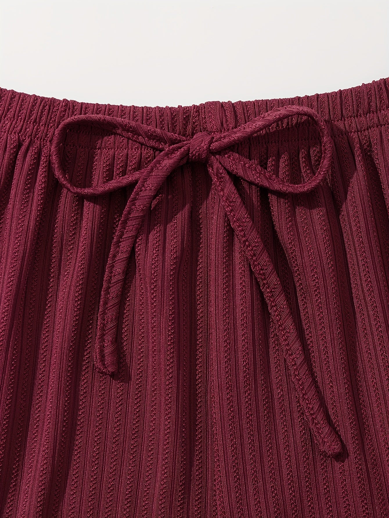 3-qismli dantel tikuvli lounge to'plami V-shaklidagi kamzuli bluzka va elastik belli shortlardan iborat bo'lib, ayollarning uyda kiyish va uxlash kiyimlari uchun mo'ljallangan.