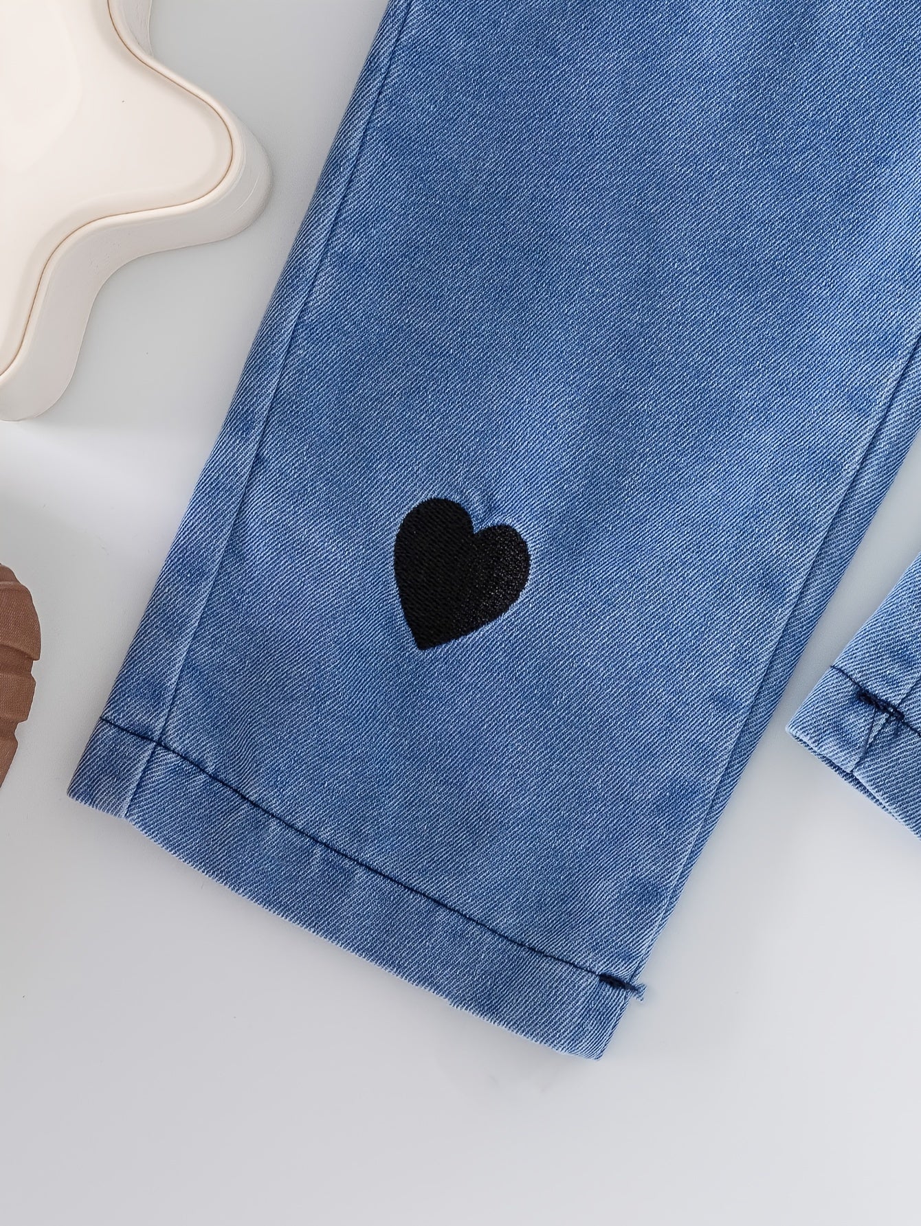 Qizlar uchun yoqimli to'plam, yurak naqshli yuqori va denim shimlarni o'z ichiga oladi, mashinada yuvish mumkin, ochiq havoda kiyish uchun ideal.