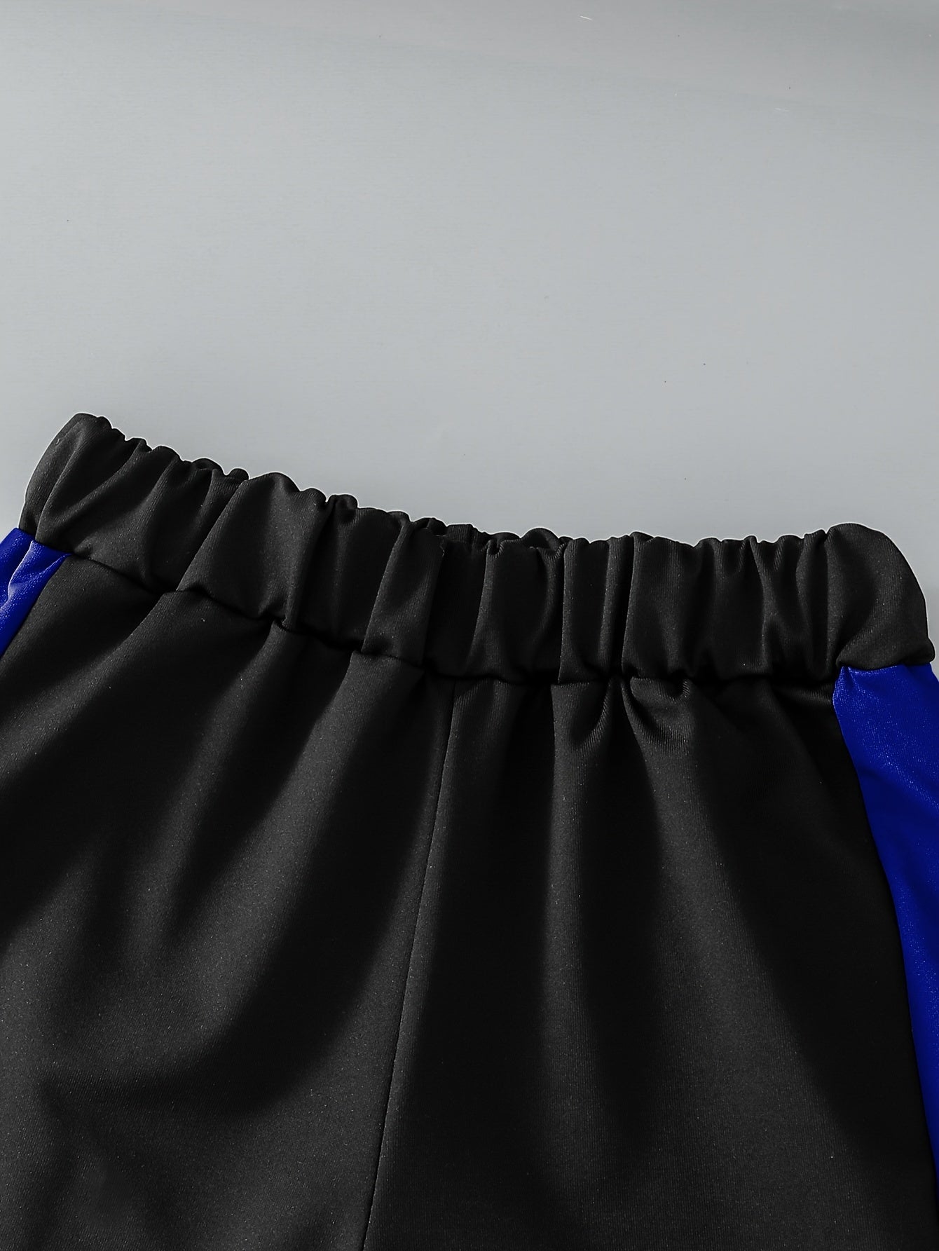 Elastik cho'ziluvchan polyester to'qilgan pullover, rangli blok dizayni bilan. O'g'il bolalar uchun keng fit, bahor/kovak fasllarida ochiq havoda faoliyatlar uchun mukammal. Mos keluvchi shimlar to'plami bilan birga keladi.