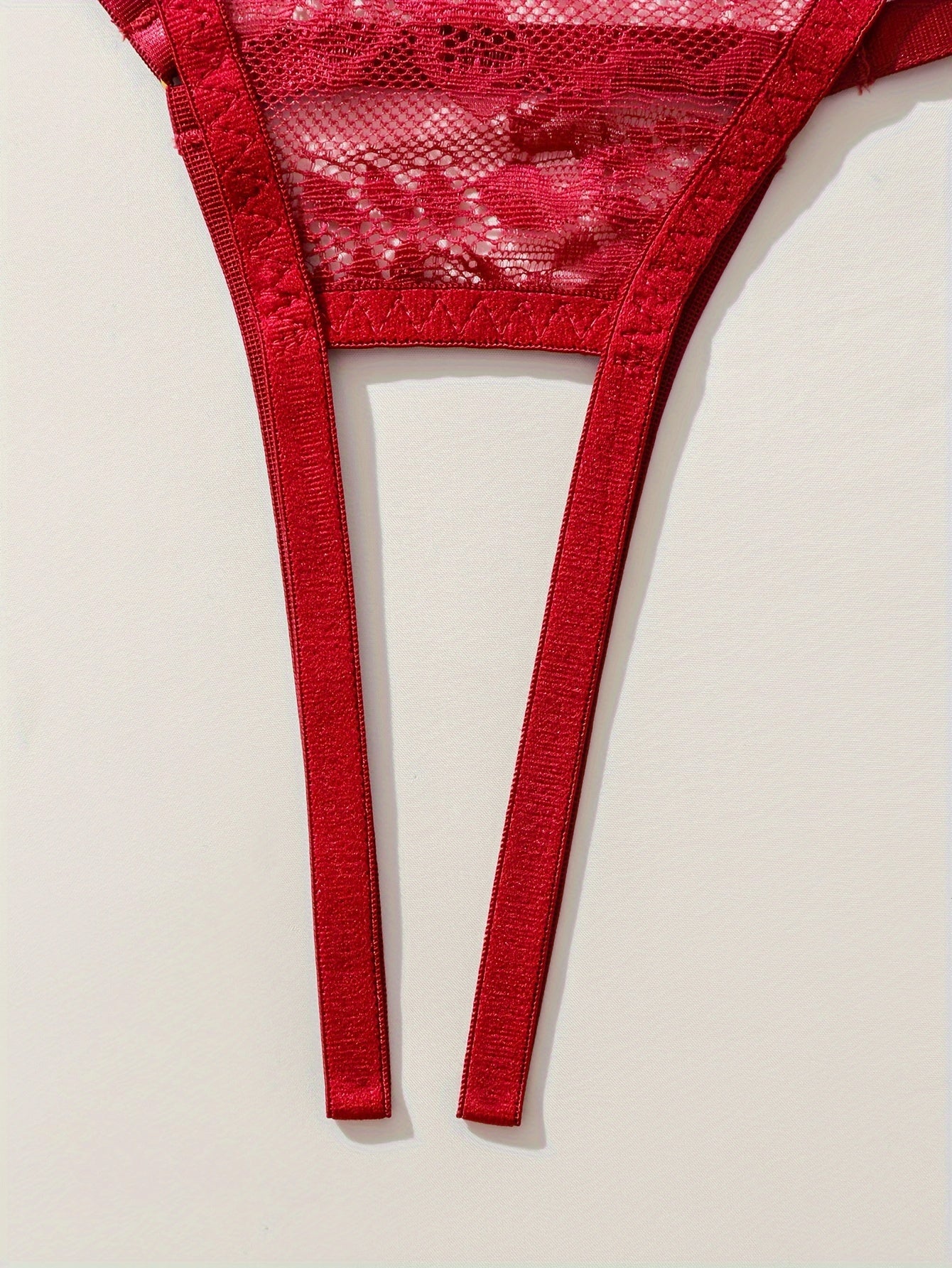 Ayollar uchun ochiq ko'krakli brassier, ochiq qorinli thong va gullar bilan bezatilgan dantelli dizayni bilan sexy kiyim to'plami.