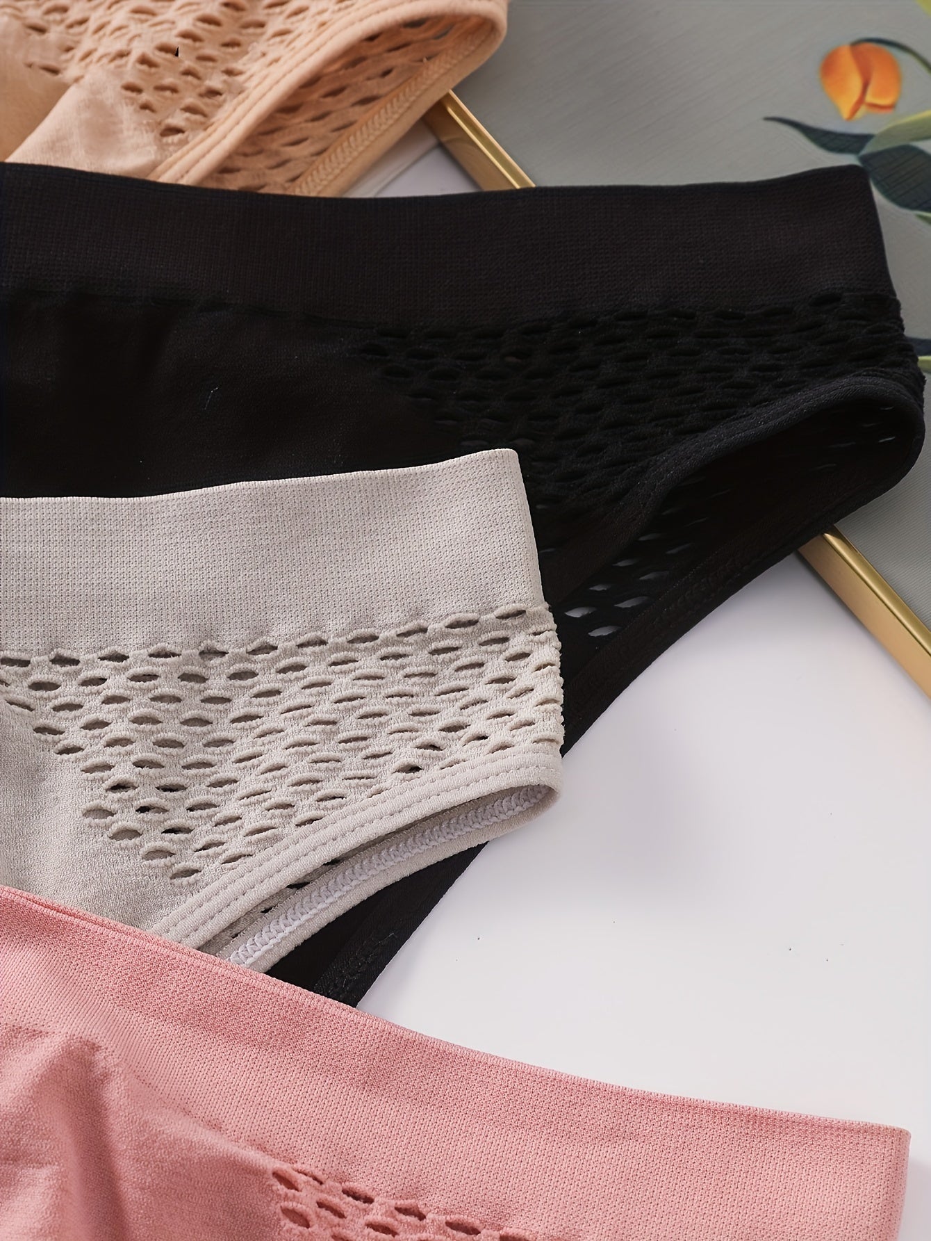 Четыре упаковки низких трусиков для женщин с вырезным дизайном и средней поддержкой. Изготовлены из смеси 90% полиамида и 10% эластана, в однотонном цвете. Легкие, плотность 200 г/м².