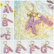 Llavero de PVC con iniciales de pedrería rosa y blanca con cierre de puño para mujeres