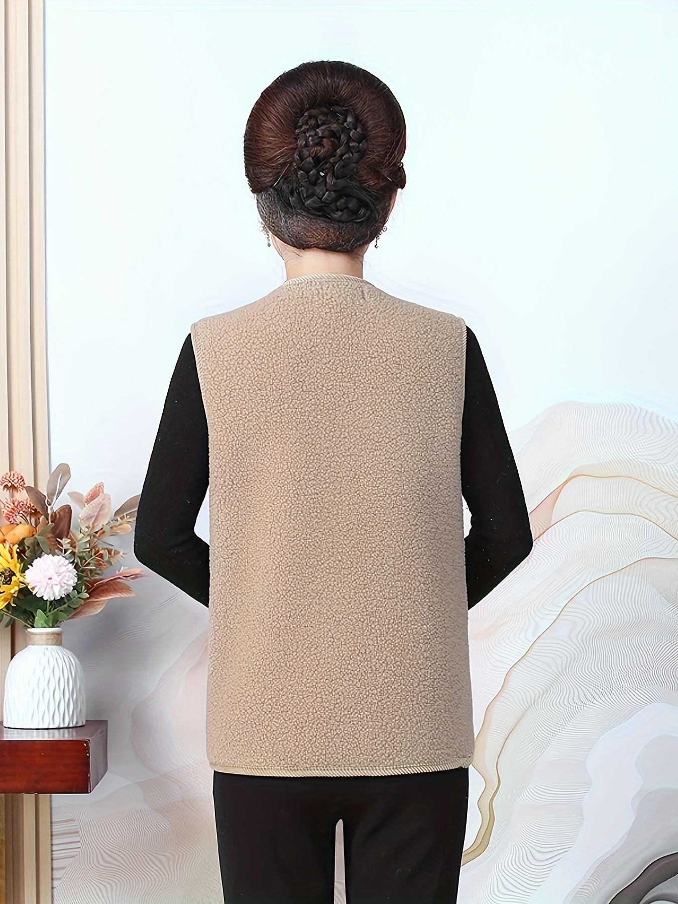 Katta o'lchamdagi ayollar uchun tasodifiy V-shaklidagi jilet, 100% polyester to'qilgan matodan tayyorlangan. Bir rangda, yengsiz, odatdagi uzunlikda va qishki issiqlik uchun yumshoq astar bilan.