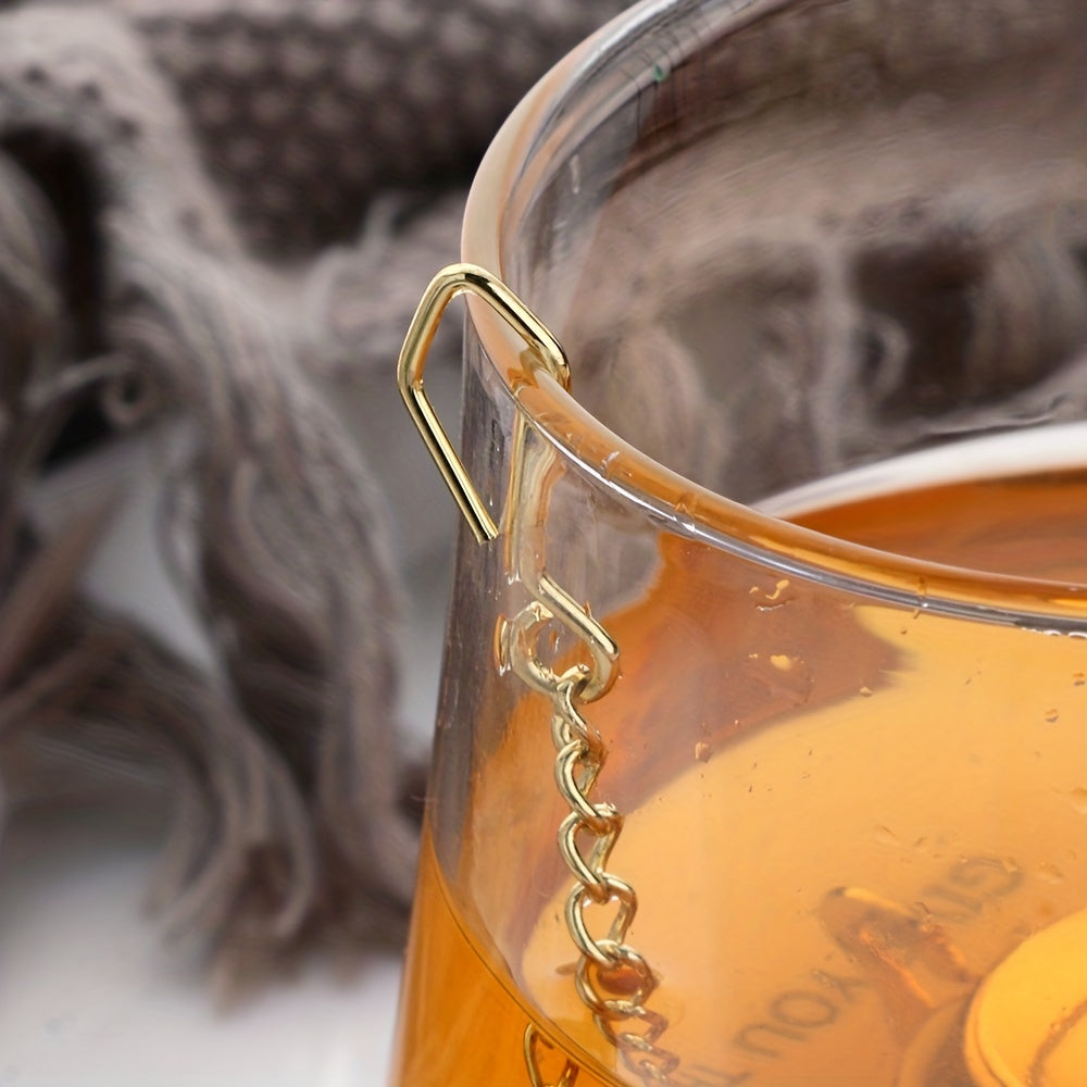 Oltin gul zanglamas po'latdan yasalgan choynak shaklidagi choy filtr, bir xil filtr teshiklari va chashkalar uchun osma zanjir bilan.