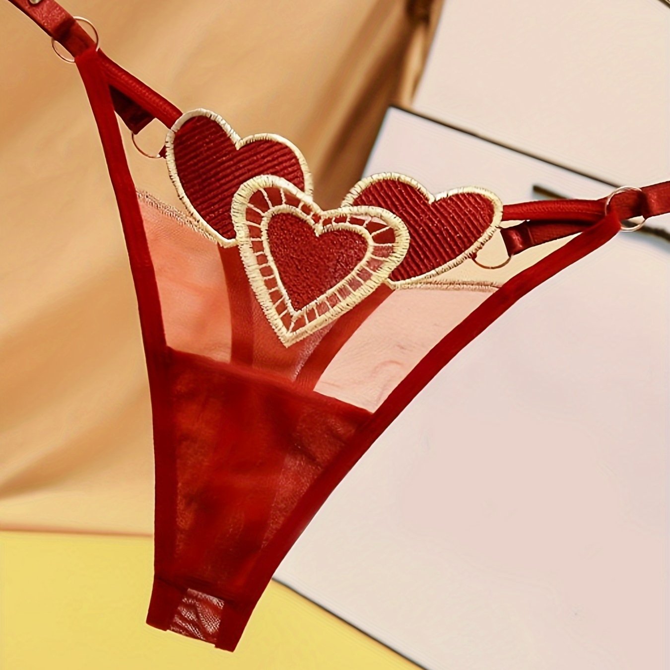 Ayollar uchun yurak naqshli thong ichki kiyim, moslashtiriladigan kattalashtirilgan o'lchamda, nafas oladigan to'r va jozibali to'qima bilan. Past bel, tungi klub uslubi, polyester materialda, S/M/L o'lchamlarida mavjud.