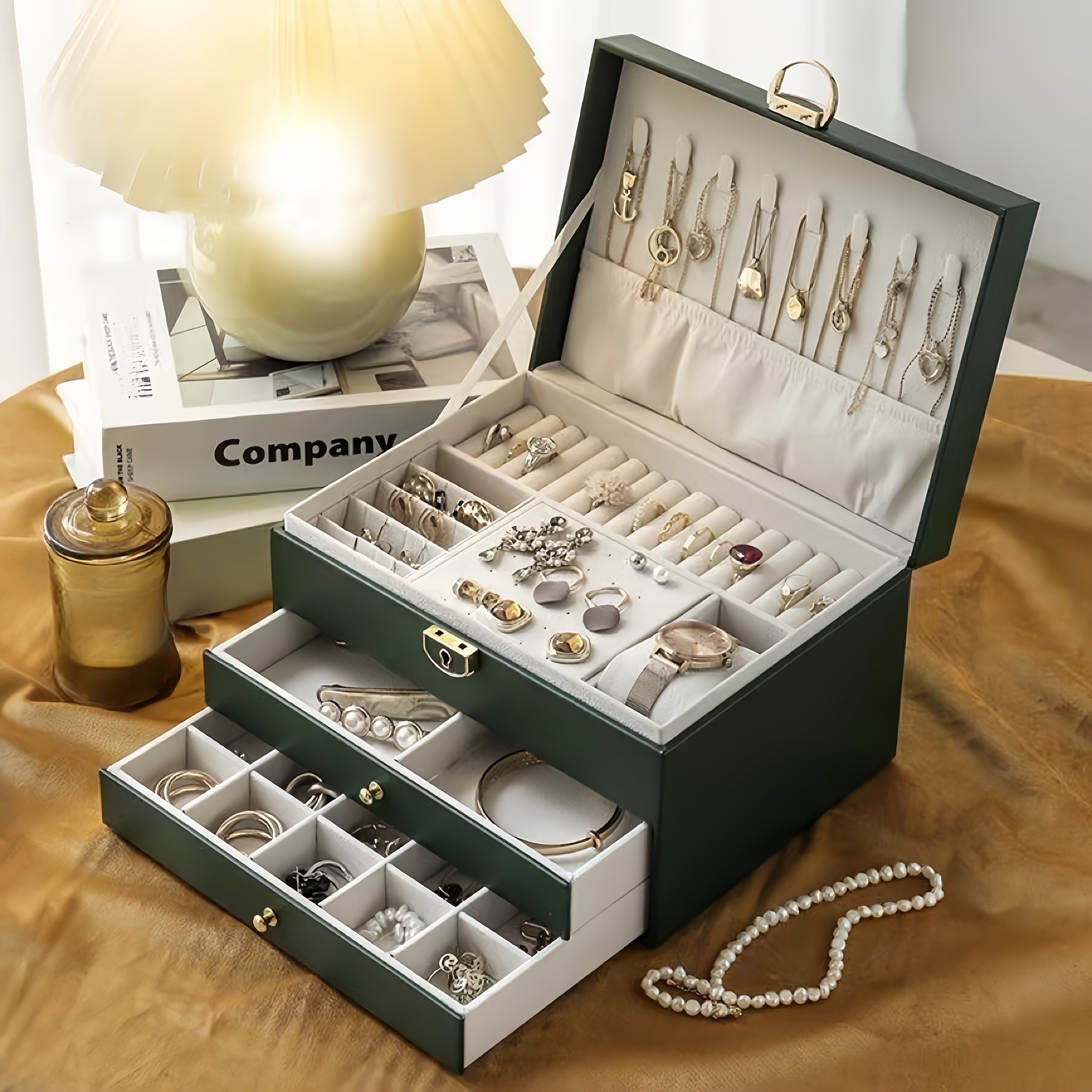 3-qavatli sun'iy charmli zargarlik saqlash qutisi, qulflangan, yumshoq qoplamali tortmalar. Marjonlar, bilakuzuklar, soatlar uchun keng joy. Yashil va oq ranglarda mavjud. Ayollar uchun mukammal sovg'a va