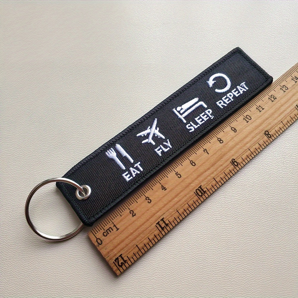 Uchta 'Yeyish, Qanot, Uxlash, Takrorlash' kalit zanjirlar to'plami, tikuv dizayni bilan. Pilotlar, aviatsiya ishqibozlari yoki hazil tuyg'usi bo'lgan har qanday kishi uchun ideal sovg'a. Kalit zanjirlar qora va oq rang kombinatsiyasida keladi.