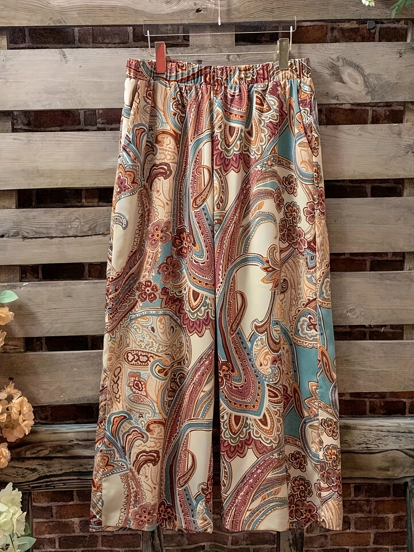 Katta o'lchamdagi ayollar uchun gullar naqshidagi ikki qismli to'plam ochiq old qismi va elastik belli shimlarni o'z ichiga oladi.