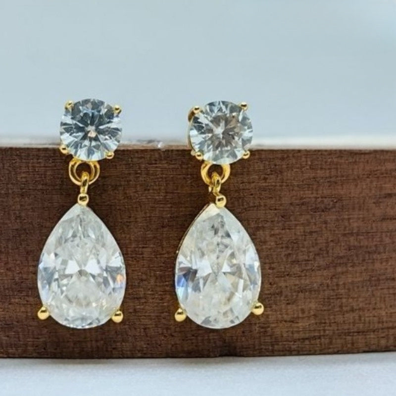 Ushbu ajoyib Vintage Teardrop Moissanite to'kma marjonlar nafislik va jozibani namoyon etadi. 925 Sterling Silver dan tayyorlangan va 18K oltin bilan qoplangan har bir marjon 2.5 karat moissanite toshiga ega. Maxsus tadbirlar va har kuni uchun mukammal.