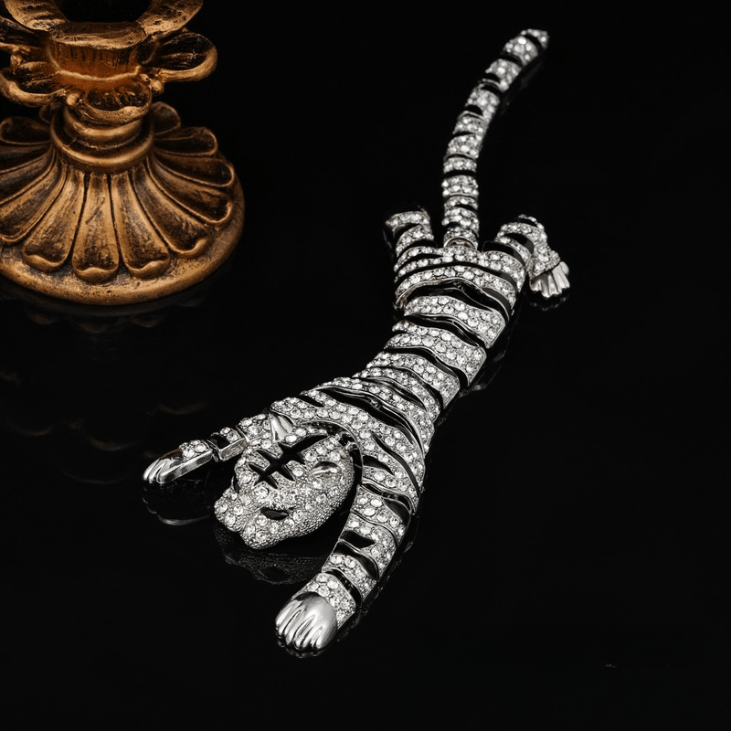 Большие броши в виде тигров с крупными стразами, драматичные булавки для шали и смелые аксессуары с животной тематикой для модных заявлений как мужчин, так и женщин.