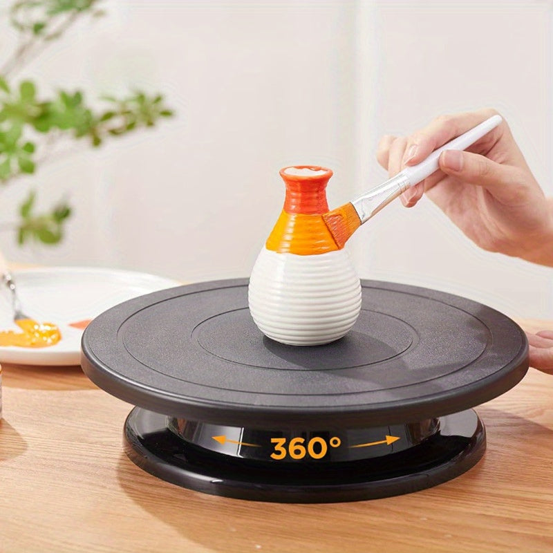 Qora tortni bezash uchun aylantiruvchi stol va kremni olib tashlash uchun scraper va spatula, plastmassadan