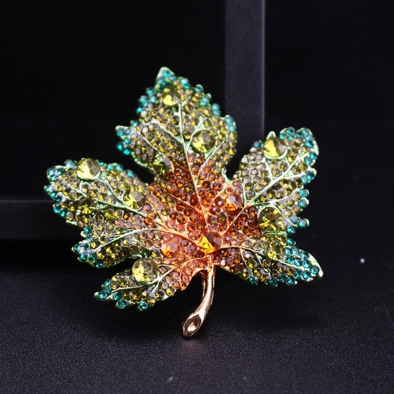 Vintage uslubidagi rhinestone qizil yaproq dizayniga ega brosh, qotishma materialdan tayyorlangan, notekis shaklda va hashamatli ko'rinish uchun to'liq olmos aksentlari bilan bezatilgan.