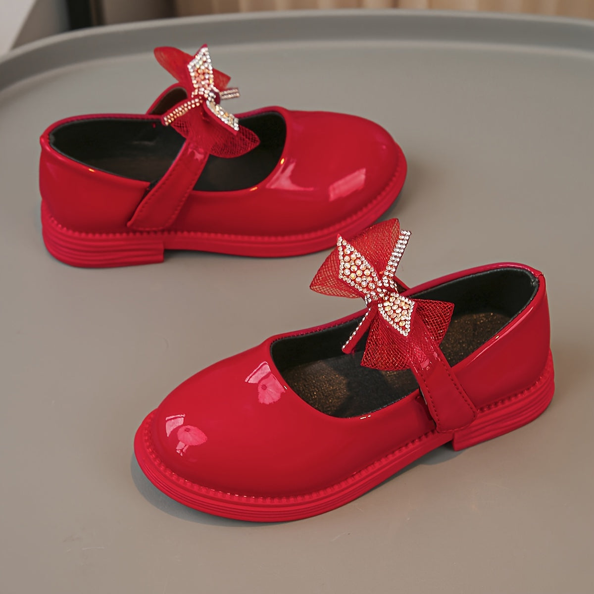 Bolalar uchun moslashuvchan tasma yopilishi, PU material, porloq kamon detali bilan bir rangli tekis poyabzal, 14 yoshgacha bo'lgan bolalar uchun mos keladi.