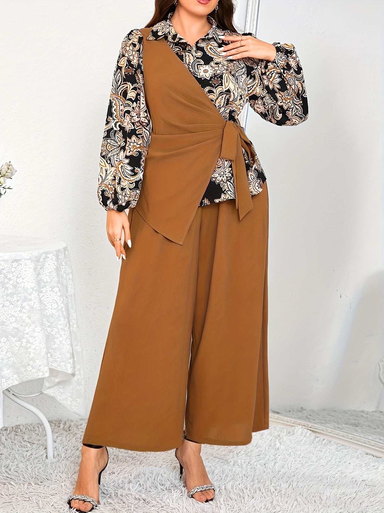 Katta o'lchamdagi ayollar uchun zamonaviy gullar bilan bezatilgan ikki qismli to'plam - bog'ichli bel detali va keng oyoqli shimlar bilan asimmetrik uzun qo'lqopli bluzka, mashinada yuvish mumkin, polyesterdan tayyorlangan.