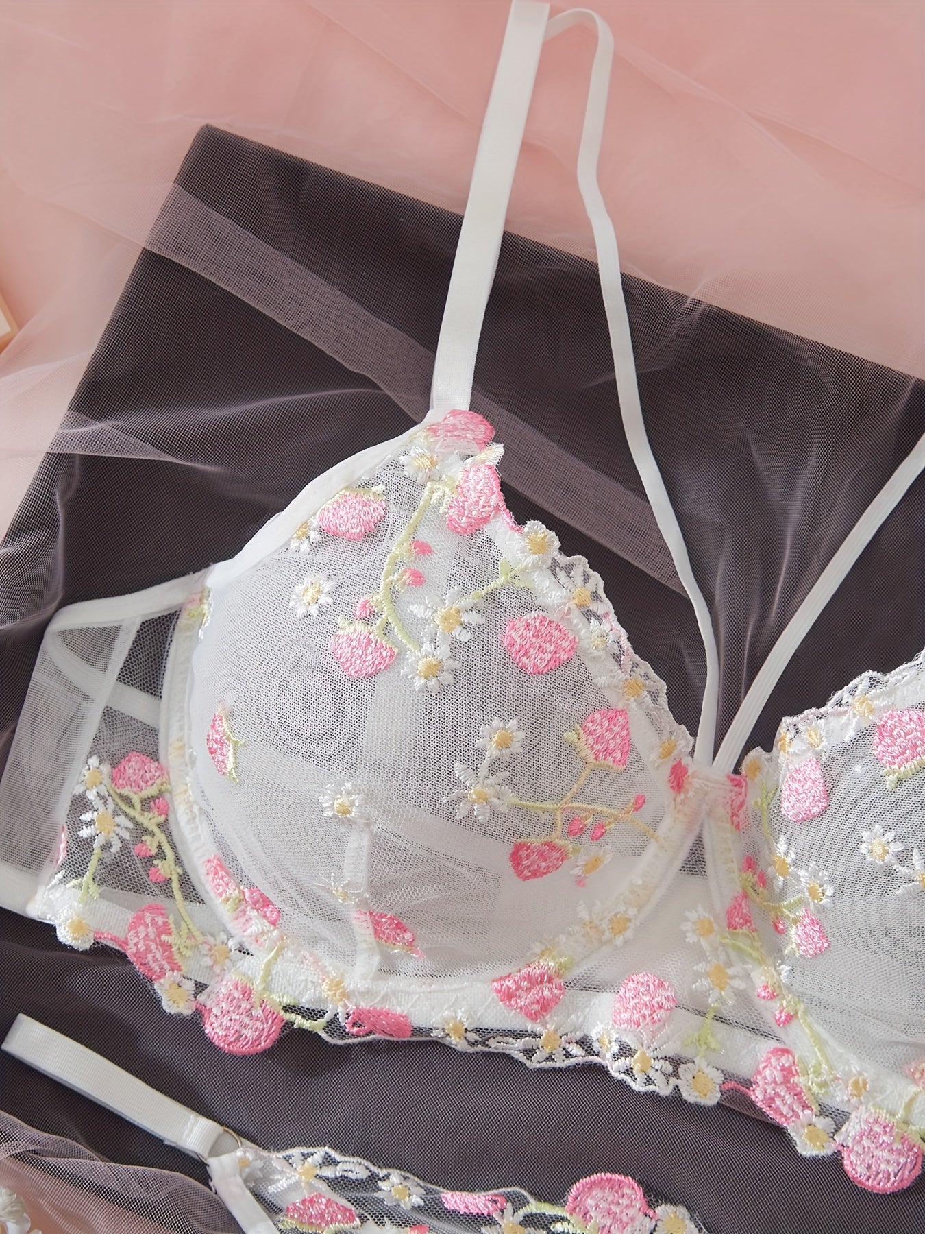 Комплект нижнего белья для женщин: бюстгальтер с цветочной вышивкой и стринги.