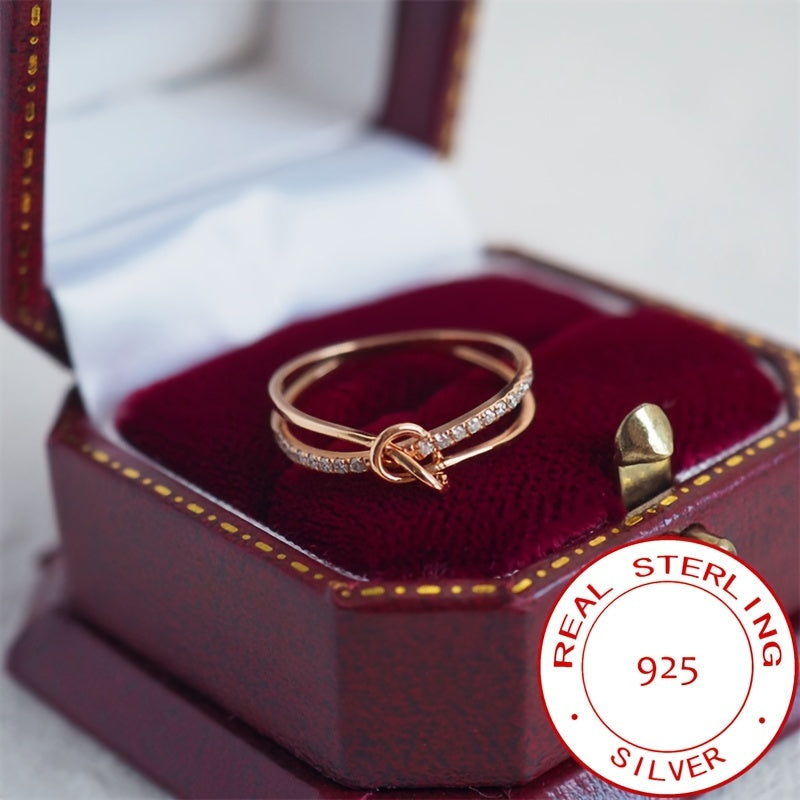 Ushbu ajoyib uzuk zamonaviy tugun dizayniga ega bo'lib, 925 sterling kumushdan tayyorlangan va porloq kubik zirkoniy aksentlari bilan bezatilgan. Bu sizning hayotingizdagi har qanday maxsus ayol uchun mukammal sovg'a.