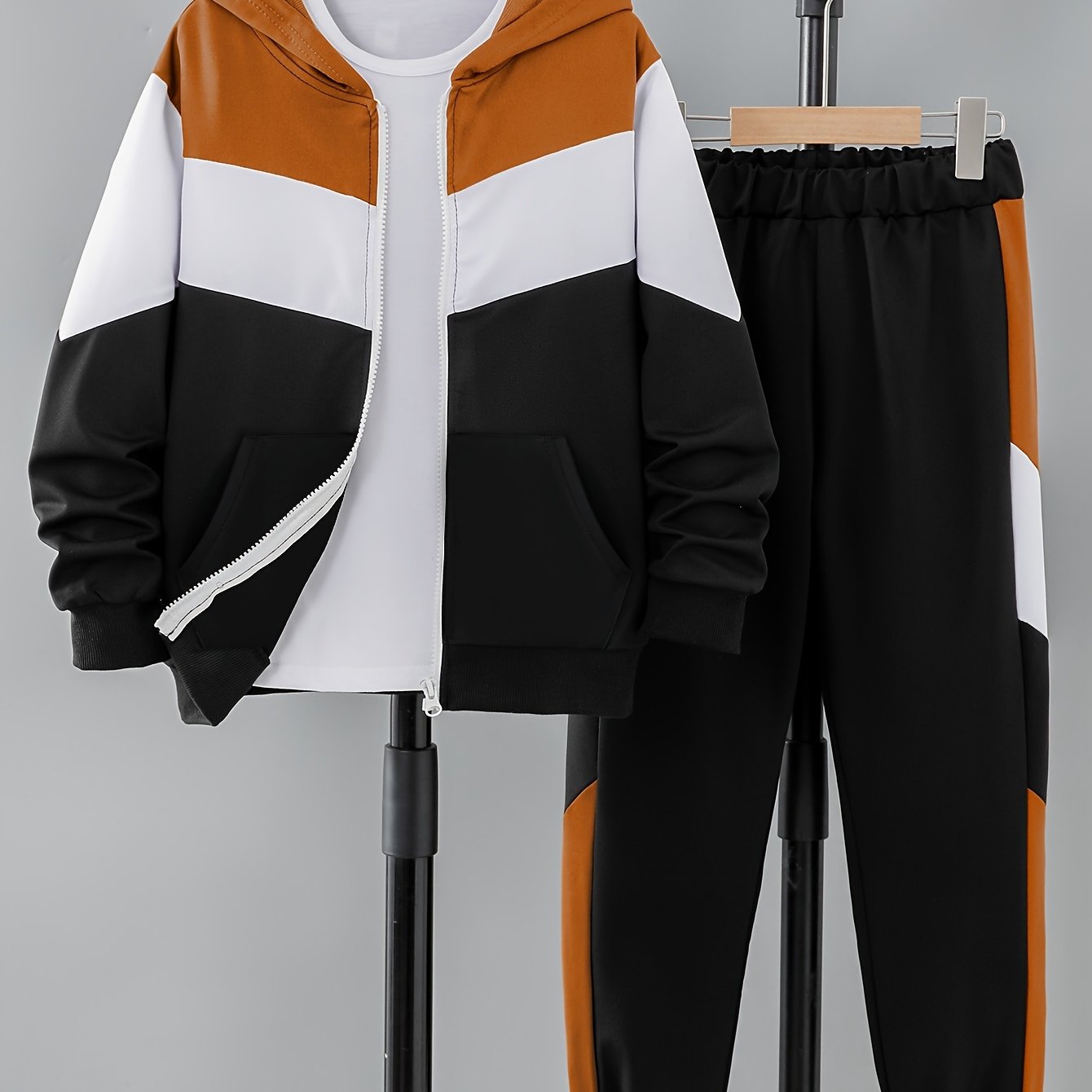 Elastik cho'ziluvchan polyester to'qilgan pullover, rangli blok dizayni bilan. O'g'il bolalar uchun keng fit, bahor/kovak fasllarida ochiq havoda faoliyatlar uchun mukammal. Mos keluvchi shimlar to'plami bilan birga keladi.