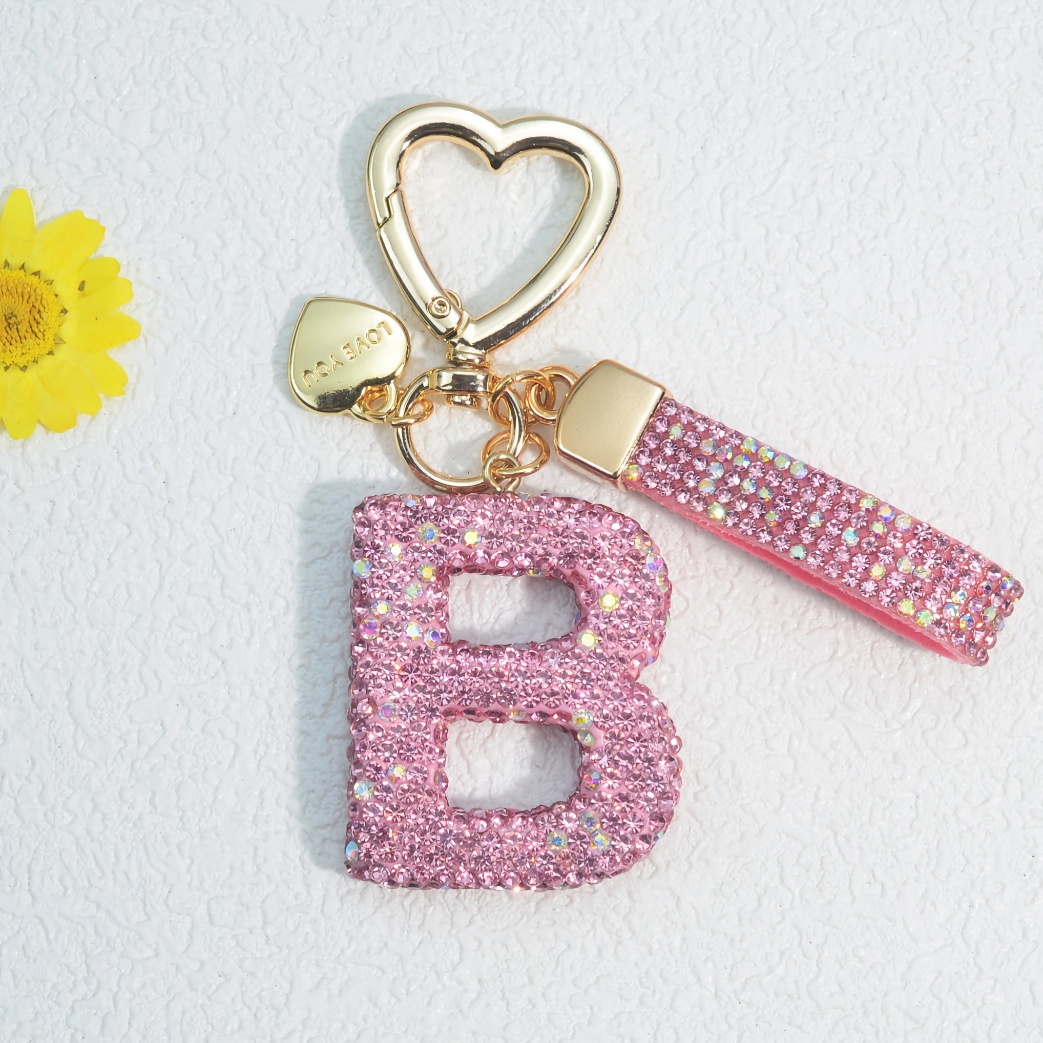 Llavero de PVC con iniciales de pedrería rosa y blanca con cierre de puño para mujeres
