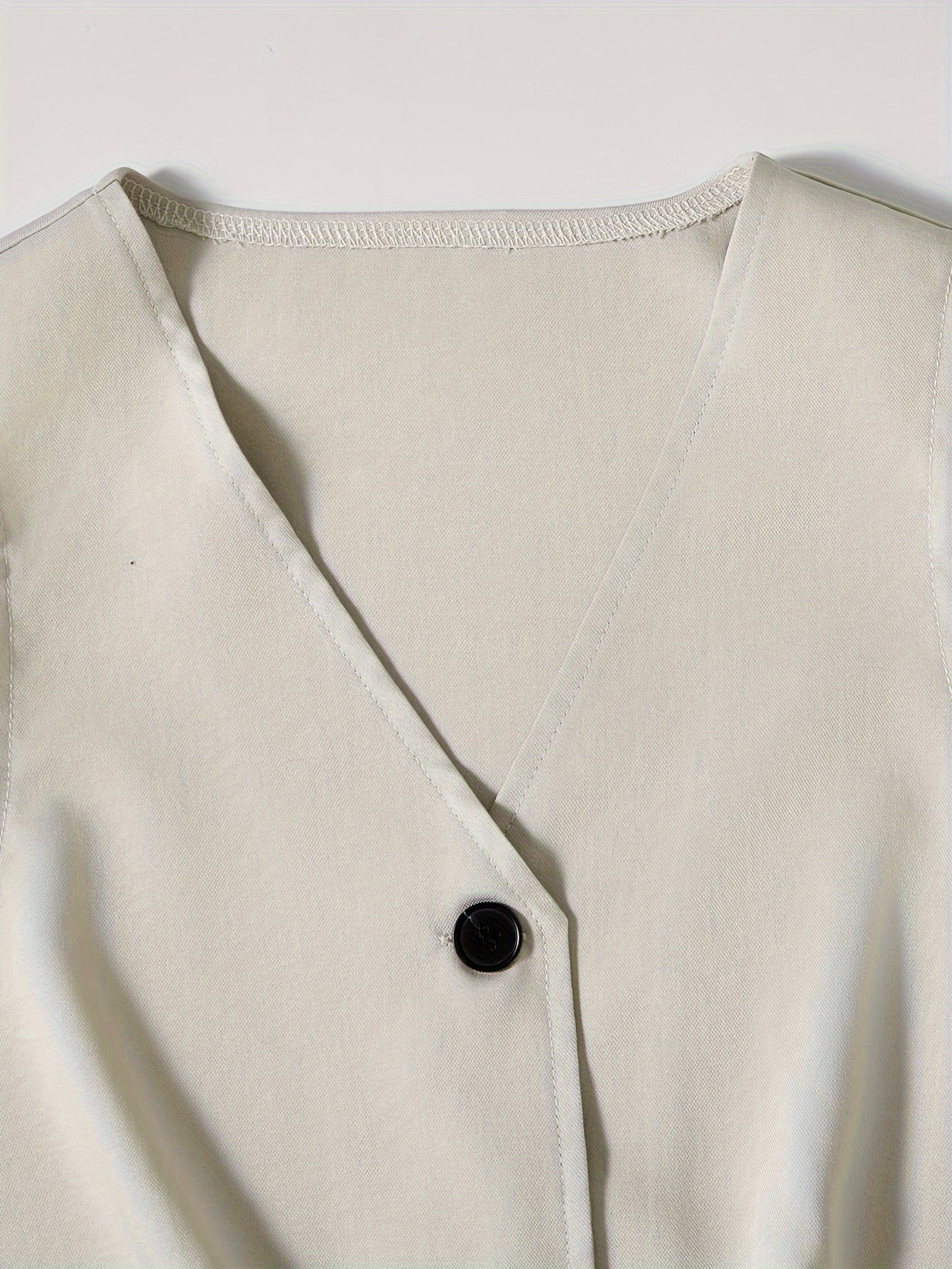 Ayollar uchun zamonaviy ikki qismli to'plam, tugma tafsilotlari bilan v-yuvalangan kesilgan vest top va yuqori belli kostyum shimlarini o'z ichiga oladi. 97% polyester va 3% elastan materialidan tayyorlangan, biroz cho'ziluvchan. Ideal for