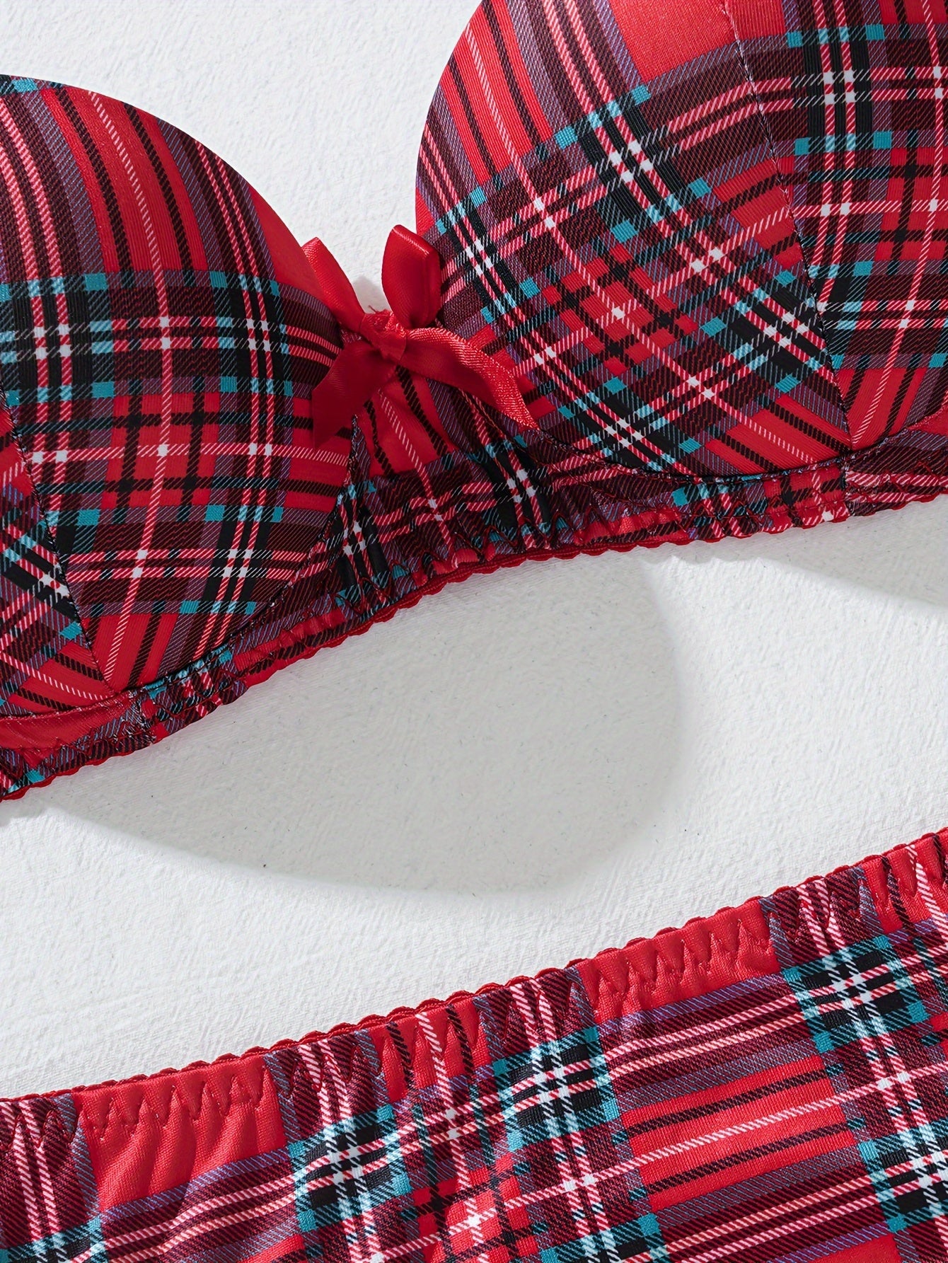 Комплект женского белья в клетку, изготовленный из 95% полиэстера и 5% эластана. Включает бюстгальтер средней поддержки и трусики средней посадки в дизайне с цветными блоками. В комплект не входит прокладка для груди. Часть взрослого белья.