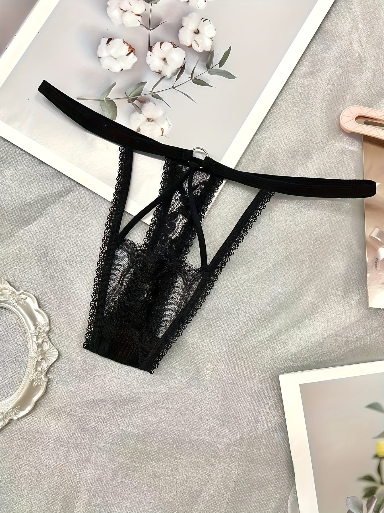 Ayollar uchun jozibali ichki kiyimlar to'rli, kesilgan past bel dizayni bilan thongni o'z ichiga oladi.