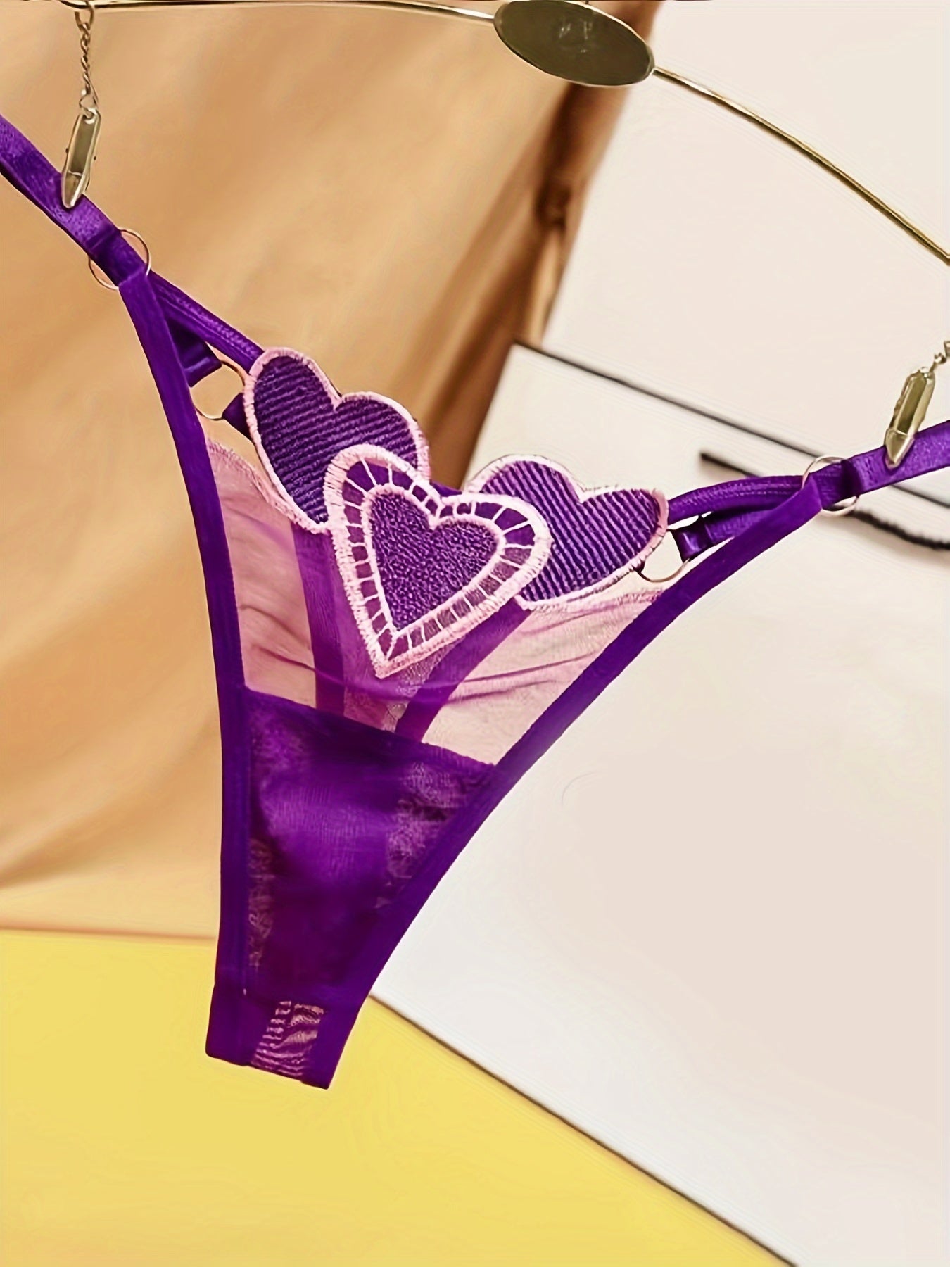 Ayollar uchun yurak naqshli thong ichki kiyim, moslashtiriladigan kattalashtirilgan o'lchamda, nafas oladigan to'r va jozibali to'qima bilan. Past bel, tungi klub uslubi, polyester materialda, S/M/L o'lchamlarida mavjud.