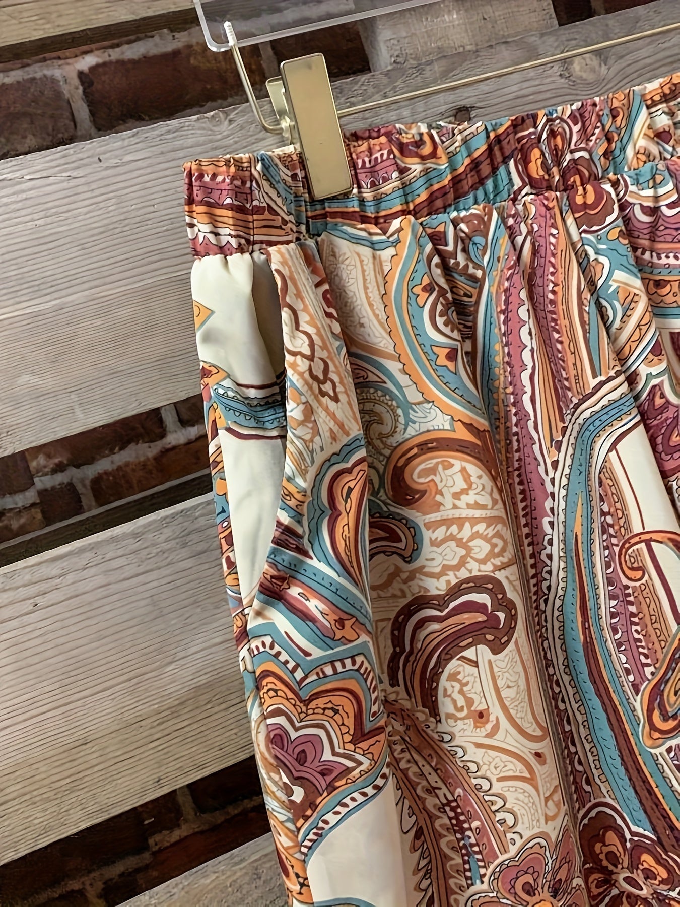 Katta o'lchamdagi ayollar uchun gullar naqshidagi ikki qismli to'plam ochiq old qismi va elastik belli shimlarni o'z ichiga oladi.