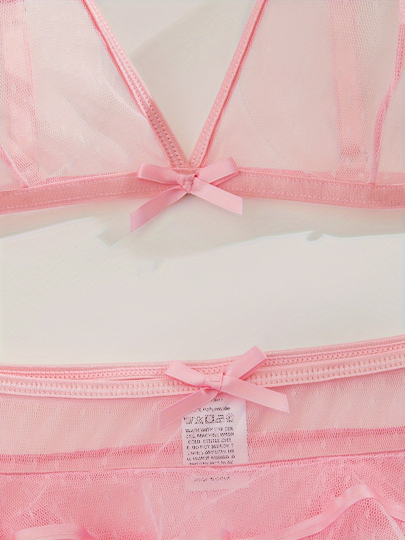 3-qismli pushti shaffof ichki kiyim to'plami ayollar uchun, pelerina, bralet va polka nuqta naqshidagi qirrali ichki kiyimdan iborat bo'lib, poliamid to'qima matosidan tayyorlangan. Nozik yotoqxona rol o'ynash uchun mukammal.