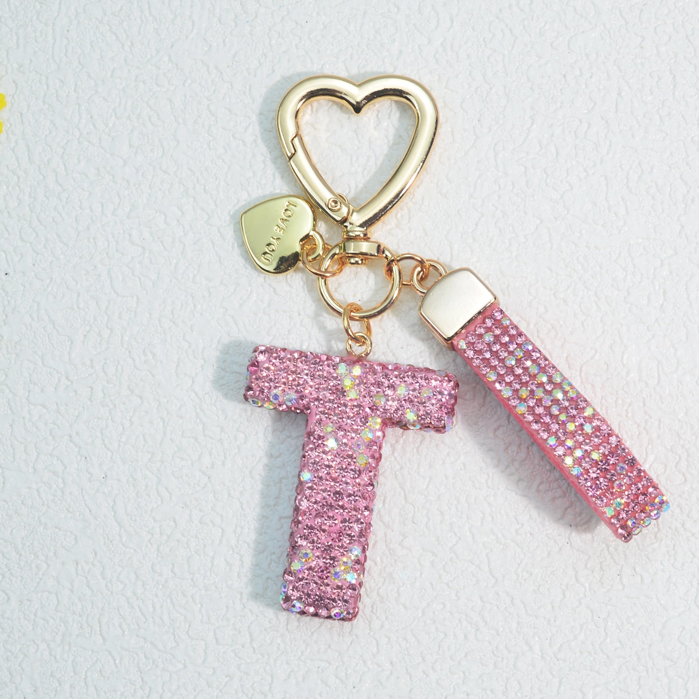 Llavero de PVC con iniciales de pedrería rosa y blanca con cierre de puño para mujeres