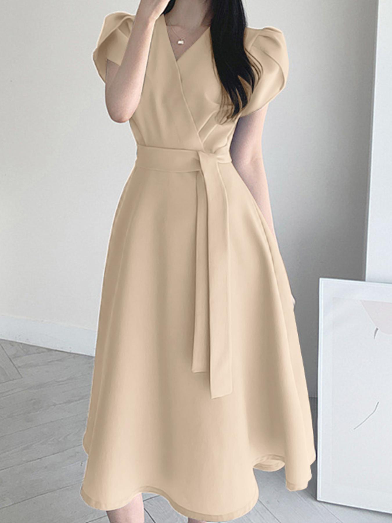 Zamonaviy V-shaklidagi A-siluetli ko'ylak, old tomonda o'ralgan, yengsiz va beli bezakli, kundalik yoki uchrashuvlar uchun. Yoz uchun engil polyesterdan tayyorlangan.