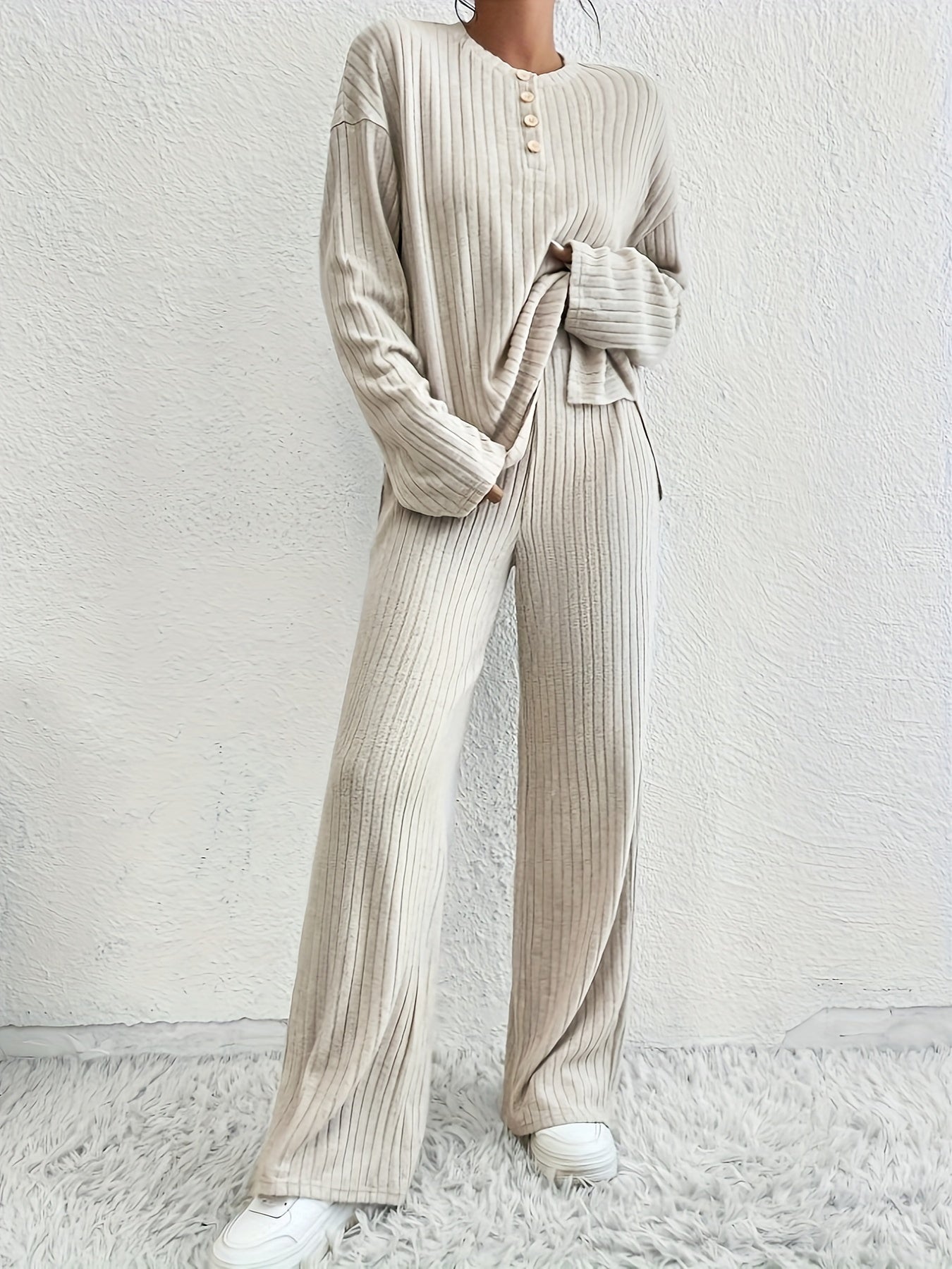 Представляем нашу новую коллекцию осень/зима для женщин: стильный комплект из двух предметов с длинными рукавами, текстурированным однотонным цветом, фальшивыми пуговицами и рифлеными спущенными плечами для повседневного образа.