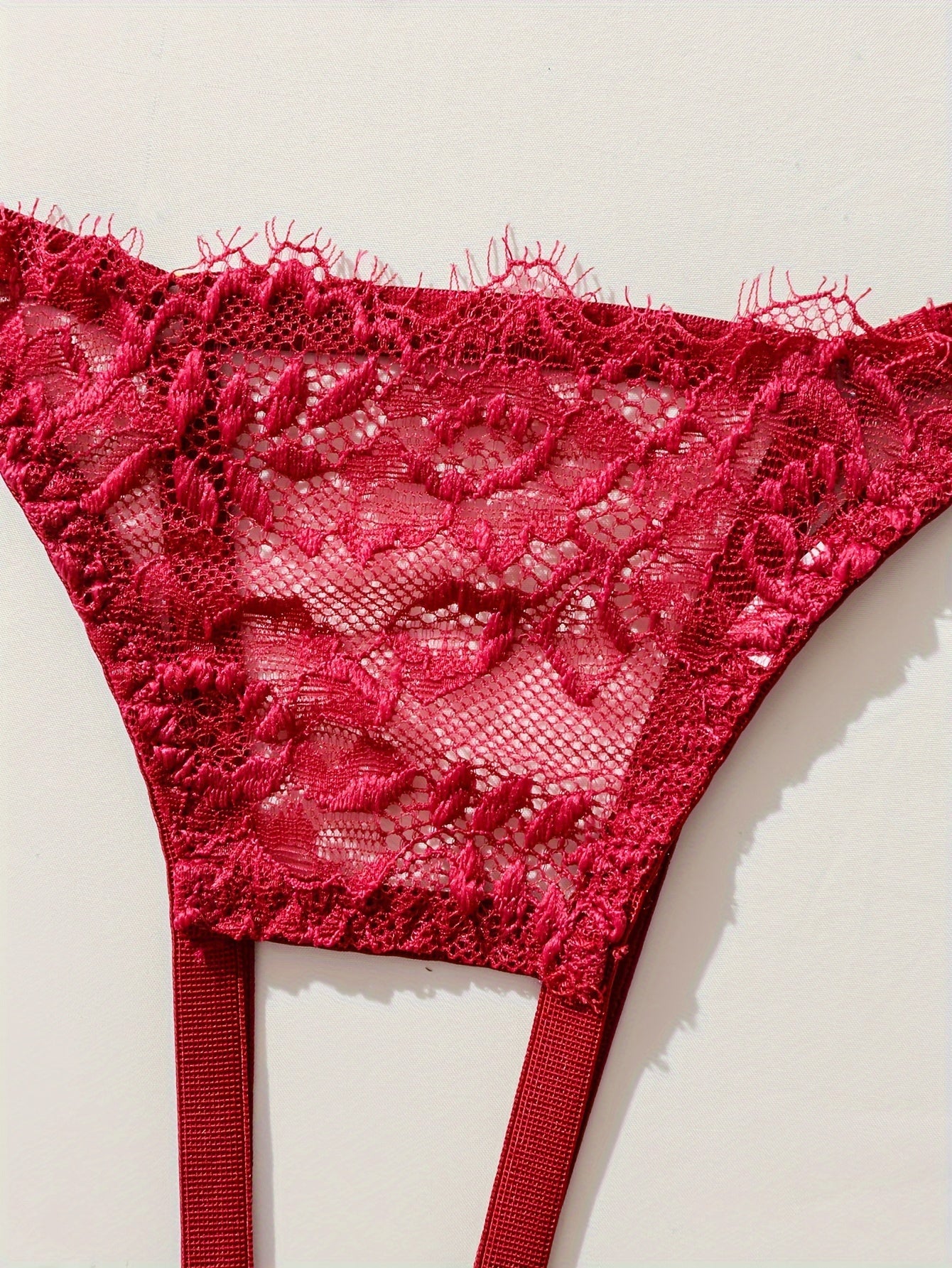 Ayollar uchun ochiq ko'krakli brassier, ochiq qorinli thong va gullar bilan bezatilgan dantelli dizayni bilan sexy kiyim to'plami.