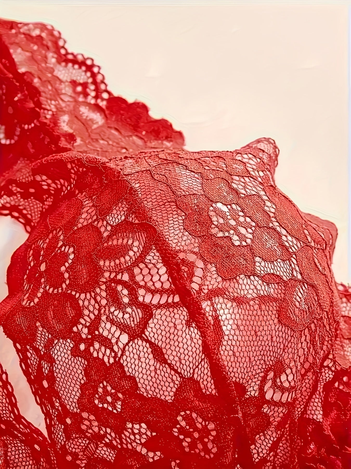 Jozibali ichki kiyim to'plami, dantel gullar naqshiga ega yarim shaffof chuqur V shaklidagi ko'ylak va thongni o'z ichiga oladi.