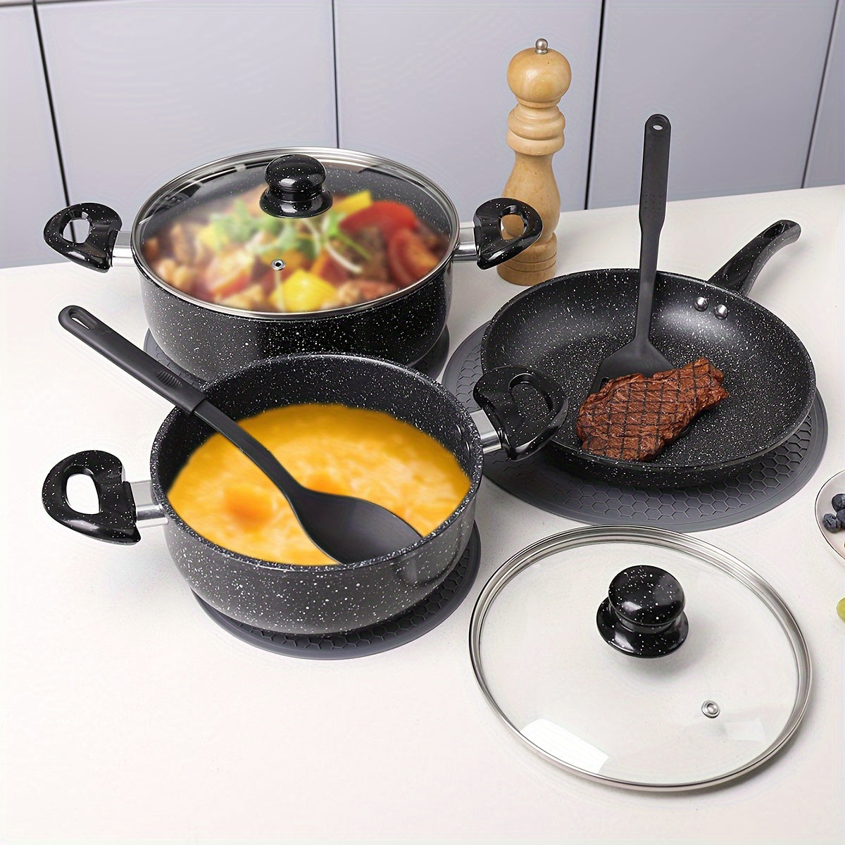 To'liq oshxona idishlari to'plami, jumladan, ikki quloqli katta sig'imli alyuminiy sho'rva qozoni, uzun tutqichli yopishqoq qovurish panasi, steak panasi, uyda ishlatiladigan sho'rva qoshiq, qovurish spatulasi va boshqa zarur pishirish aksessuarlar.