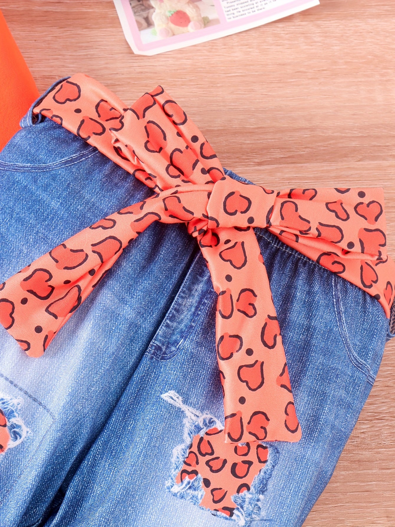 Bola va kichik qizlar uchun 3 qismli ochiq kiyim to'plami, uzun qo'lqonli multfilm ustki qismi va belbog'li soxta jinsilar, qiz bola boshining chiroyli printi bilan.