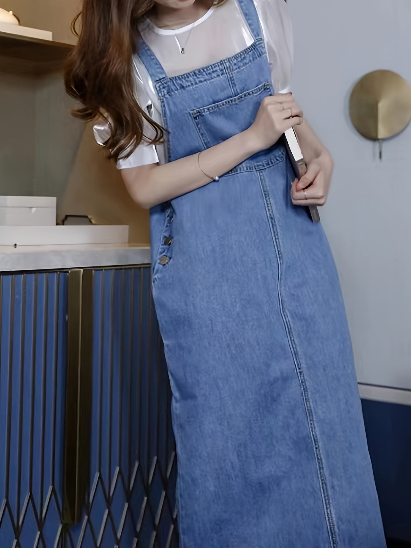 Ayollar uchun old tomonida cho'ntaklari bo'lgan keng kesimli denim overall ko'ylagi.