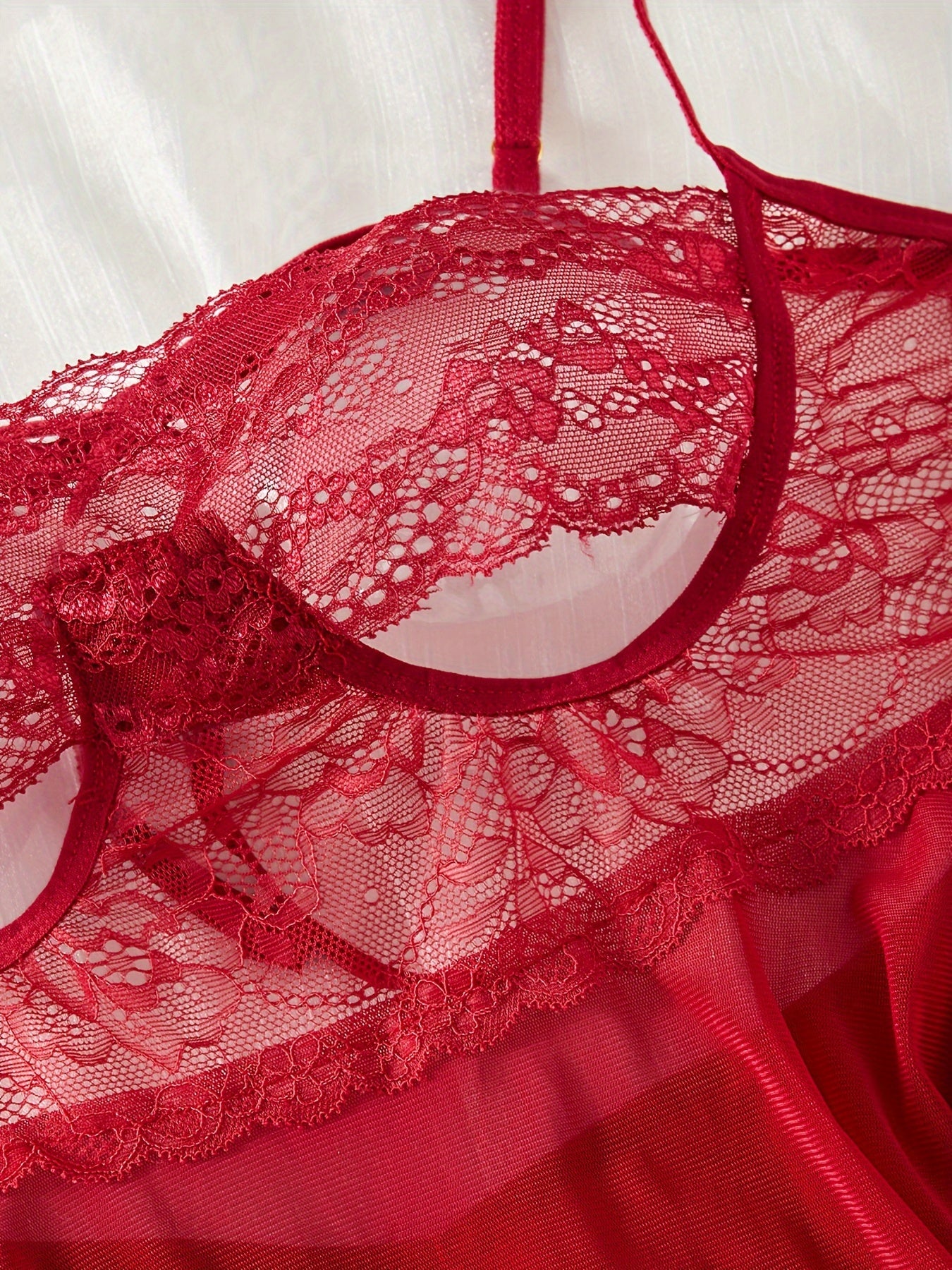 Ayollar uchun jozibali ichki kiyim to'plami, dantel slip ko'ylagi, thong va chokerdan iborat.