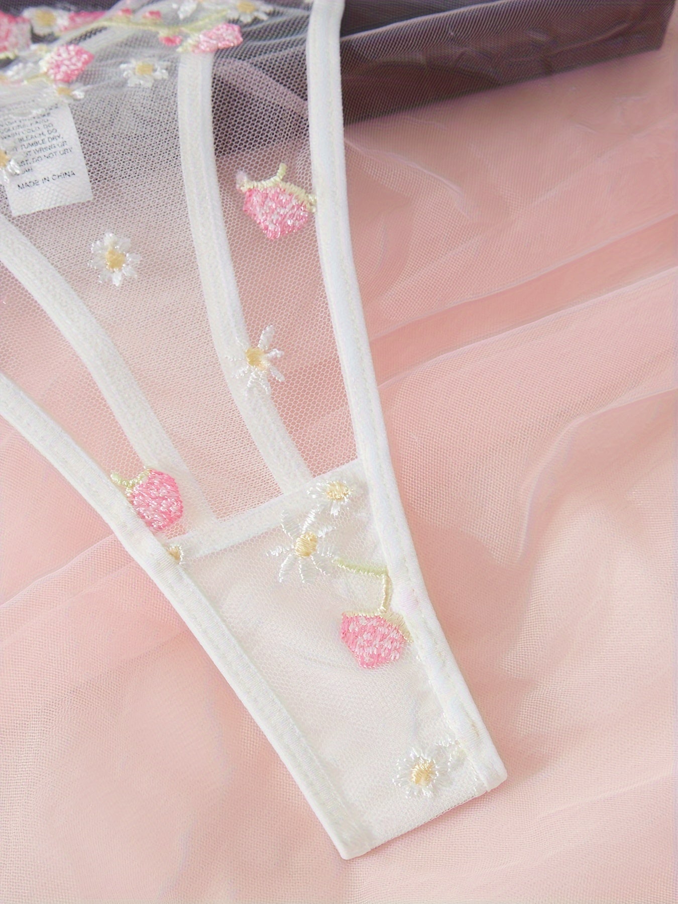 Комплект нижнего белья для женщин: бюстгальтер с цветочной вышивкой и стринги.