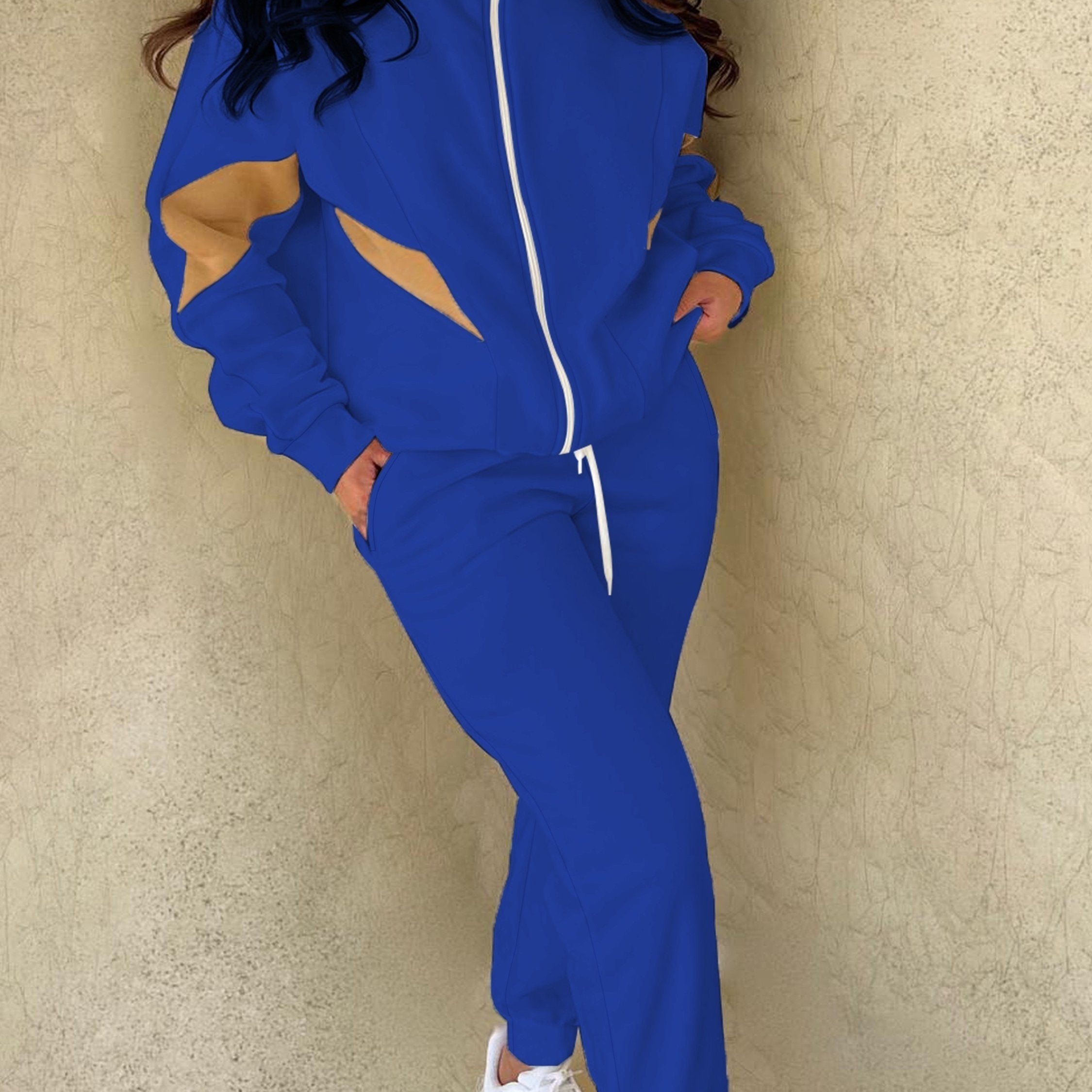 Ayollar uchun tasodifiy sport uslubidagi ikki qismli to'plam: cho'ziladigan cho'ntaklari va tortish qismiga ega ko'k va sariq fermuarli kurtka va mashinada yuvilishi mumkin bo'lgan polyester aralashmasidan tayyorlangan sport shimlar.