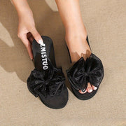 Gul bog‘ichli, qora wedge flip-floplar, kiyish uchun qulay dizayn, mustahkam, sirpanmaydigan EVA material, qulay mato yuqori qismi. Yozgi plyaj sayohatlari uchun mukammal.