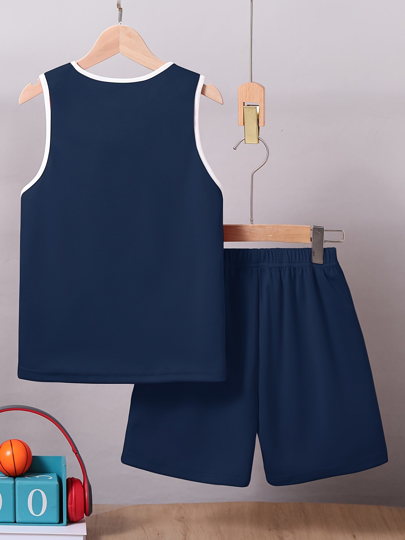 Ikki qismli o'g'il bolalar basketbol formasi to'plami, KING yozuvi bilan, yengsiz ko'ylak va trening va musobaqalar uchun shortilar, tez quriydigan tank top va shortilarni o'z ichiga oladi.