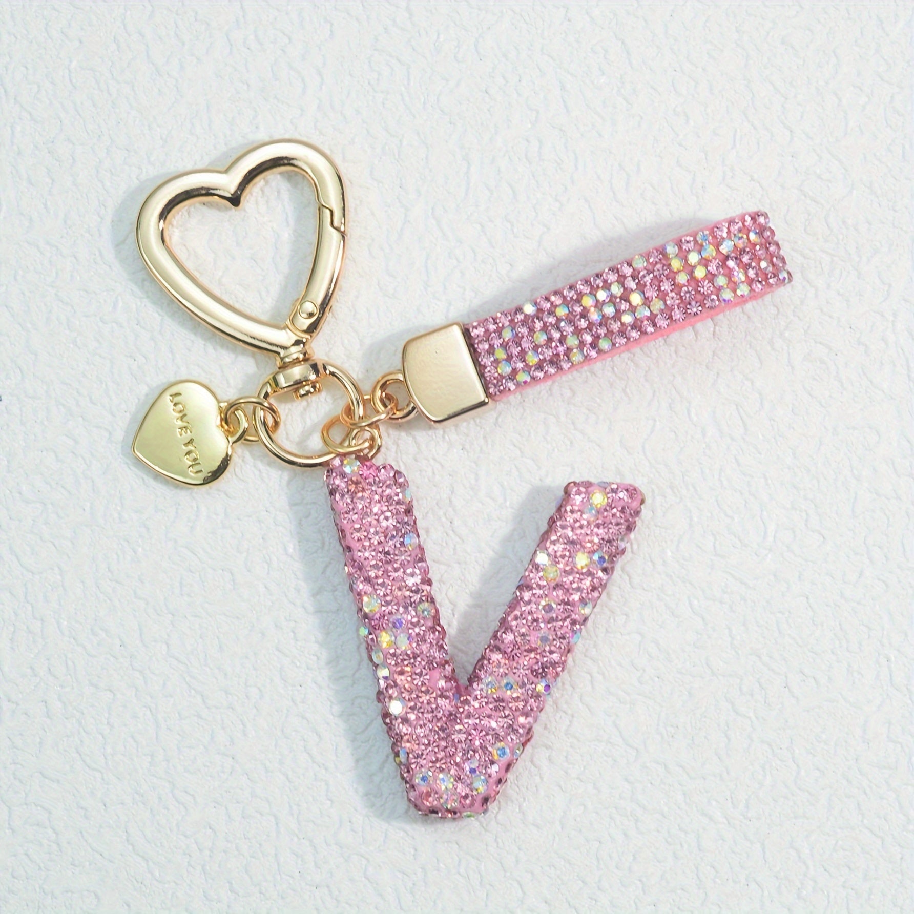 Llavero de PVC con iniciales de pedrería rosa y blanca con cierre de puño para mujeres