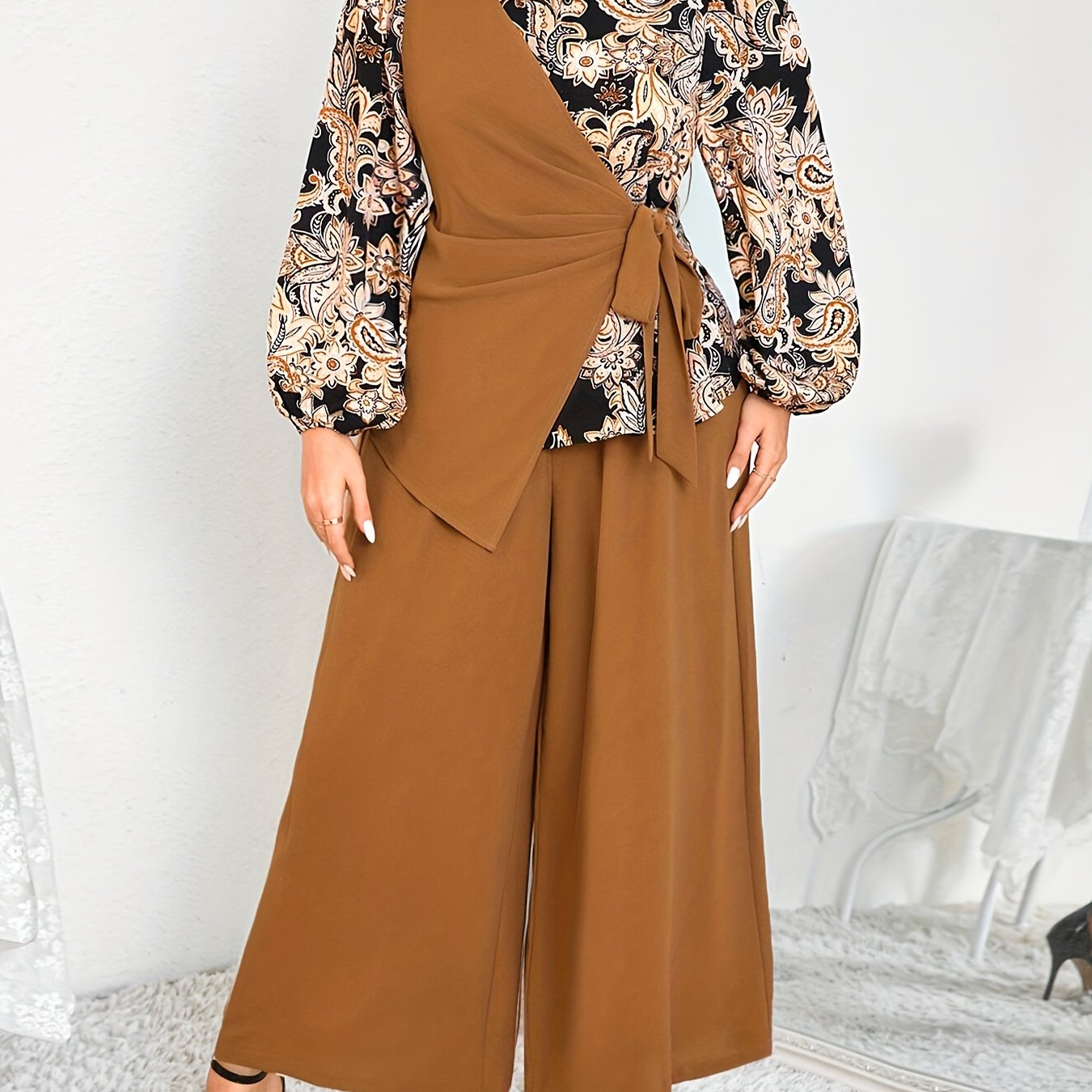 Katta o'lchamdagi ayollar uchun zamonaviy gullar bilan bezatilgan ikki qismli to'plam - bog'ichli bel detali va keng oyoqli shimlar bilan asimmetrik uzun qo'lqopli bluzka, mashinada yuvish mumkin, polyesterdan tayyorlangan.