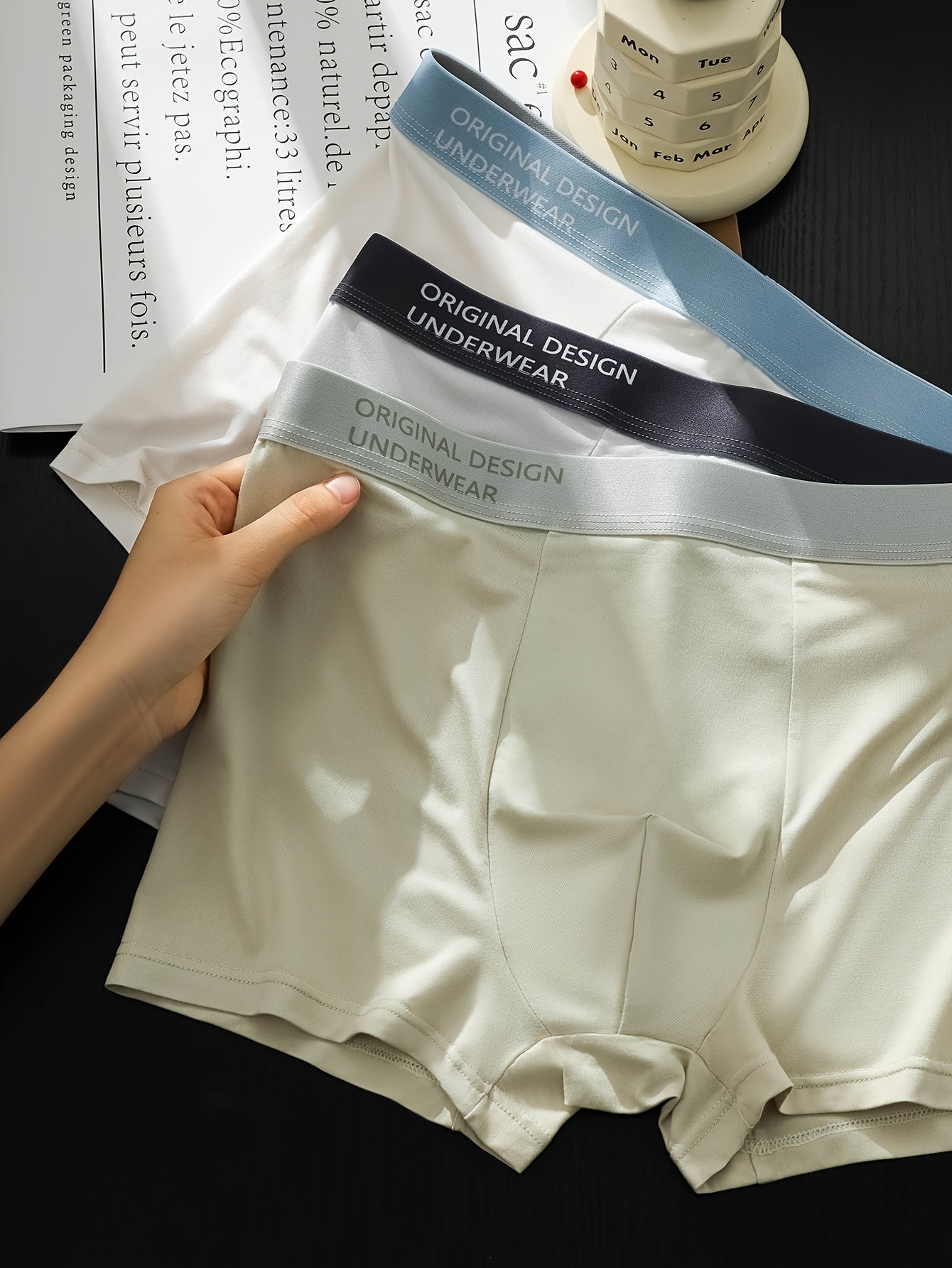 Erkaklar uchun ikki rangli boxer shortlar, nafas oladigan polyester spandeks aralashmasidan tayyorlangan, o'rtacha cho'ziluvchan trikotaj mato. Tropik naqsh va qarama-qarshi bog'ich bilan bezatilgan, kundalik kiyish uchun mukammal.