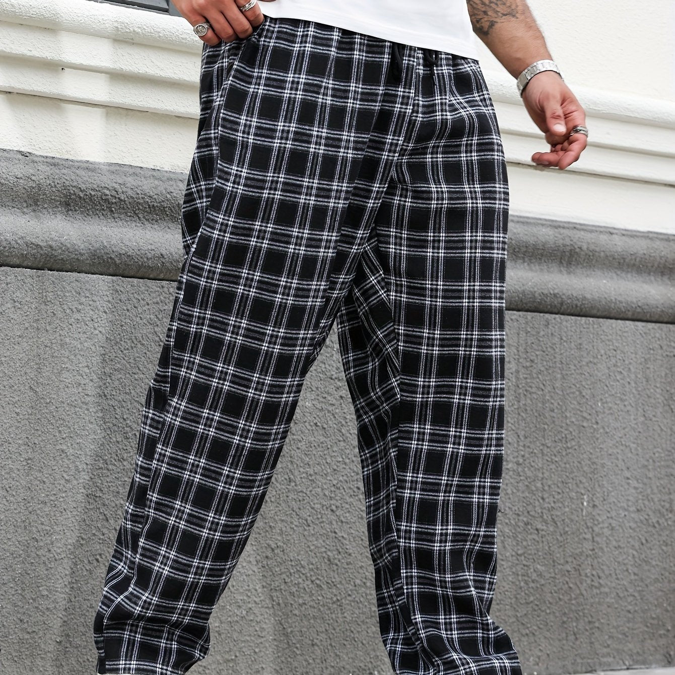 Katta o'lchamdagi erkaklar uchun qora va oq tekis naqshli tasma shimlar, to'g'ri kesimda, barcha mavsumlar uchun mos keladigan cho'zilmaydigan polyesterdan tayyorlangan va cho'ntaklar bilan ta'minlangan.