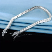 To'rtburchak, porloq zirkoni tennis bilaguzukini o'z ichiga olgan nafis qo'l zargarlik bezaklari.